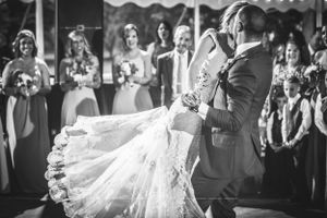 Groom joyfully picks up bride during dancing at a wedding