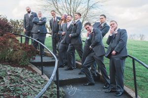 Groomsmen pose for funny photo on winding stairs
