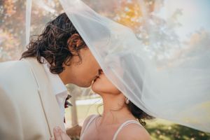 Groom kisses bride beneath her veil