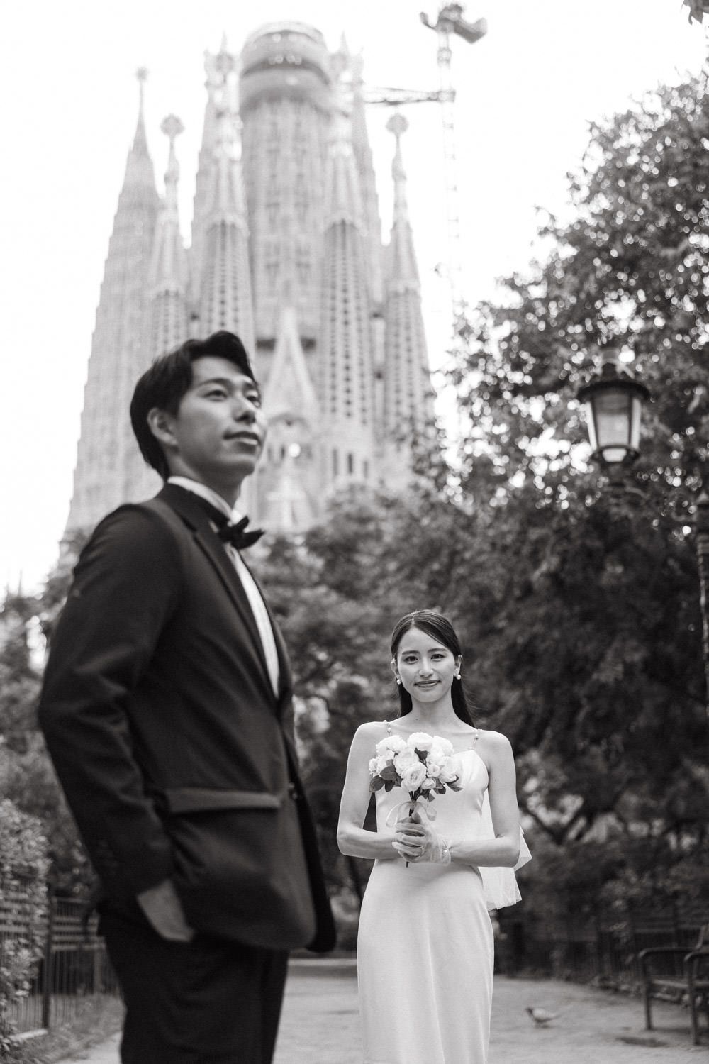 A couple poses romantically in front of the iconic Sagrada Familia cathedral in Barcelona.