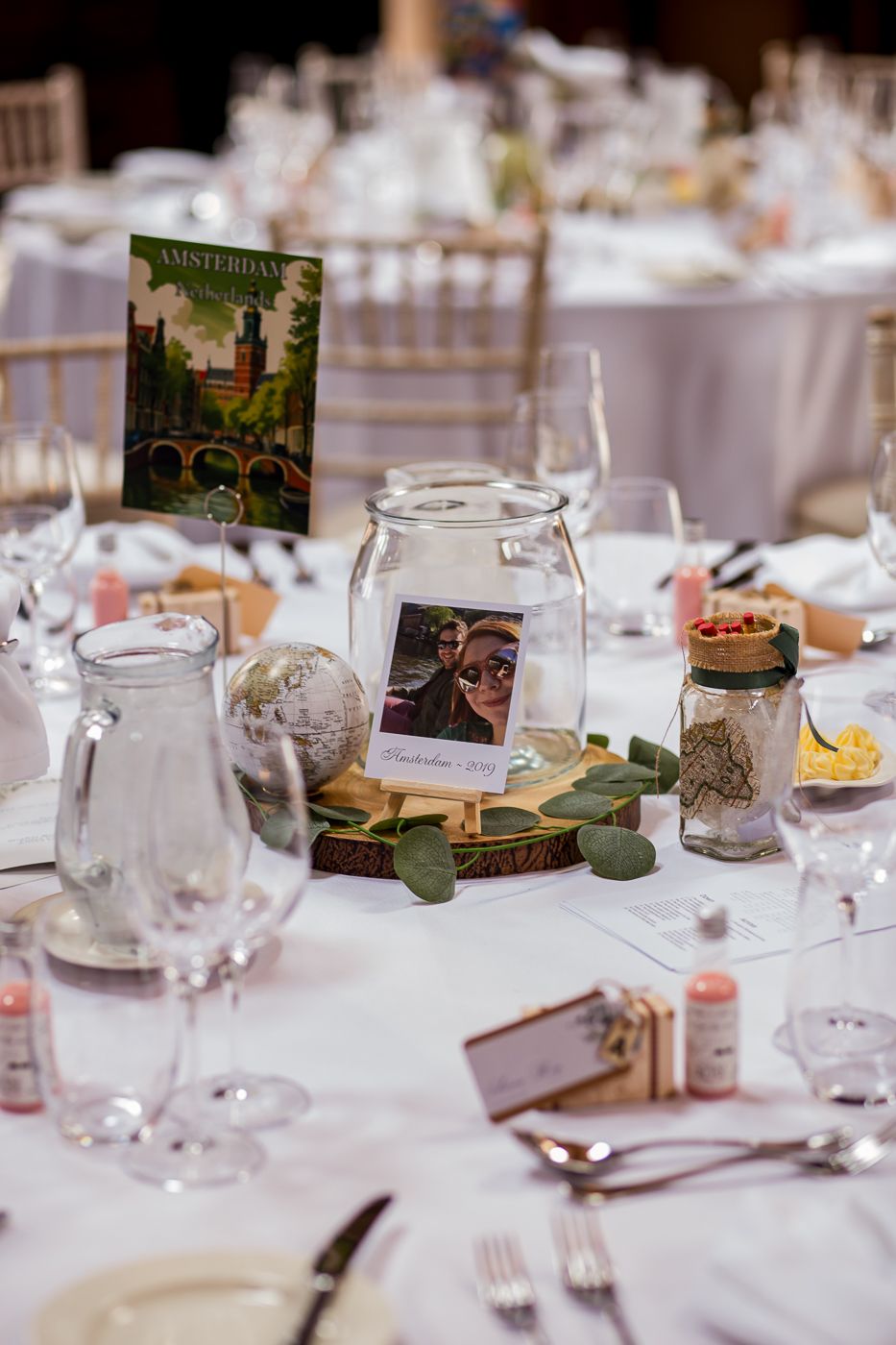 Wedding reception table settings with white linens and vintage-inspired centerpiece decorations.