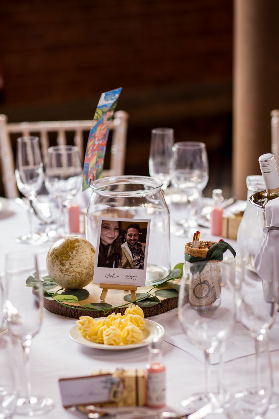 Formal table settings with wine glasses and personalized photo decorations at wedding reception.