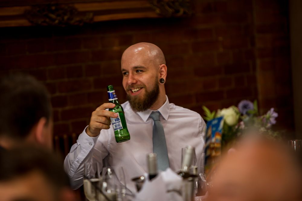 Wedding guests raise their drinks in a celebratory toast during reception speeches.