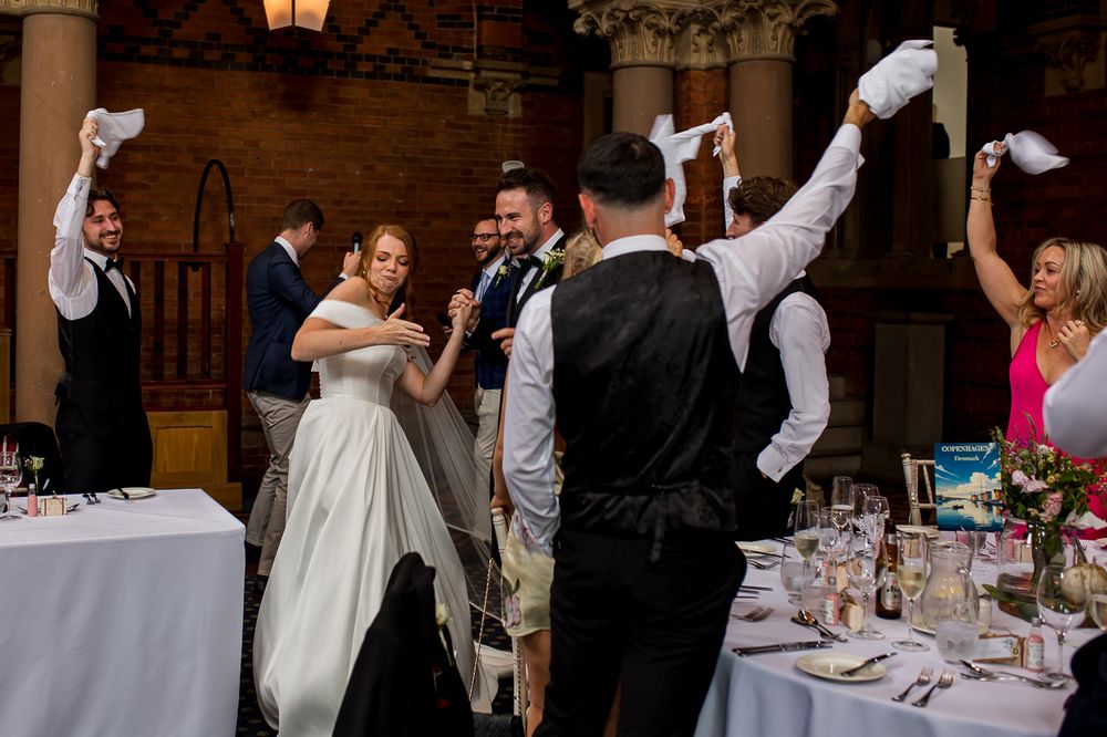 Wedding celebration with guests waving white napkins in unison across the reception hall.