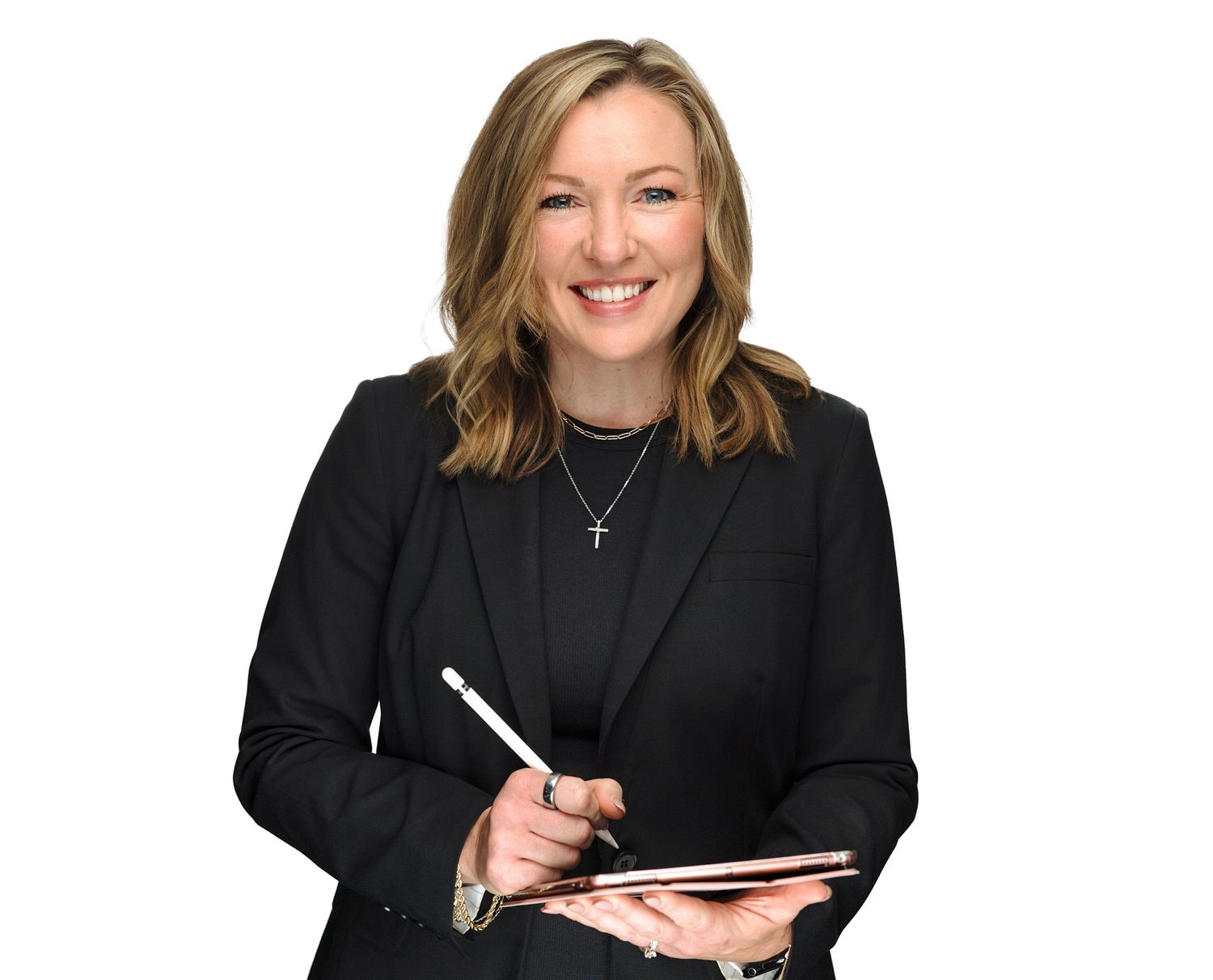 Professional headshot series of a person in black attire against a white background shown in four similar poses.