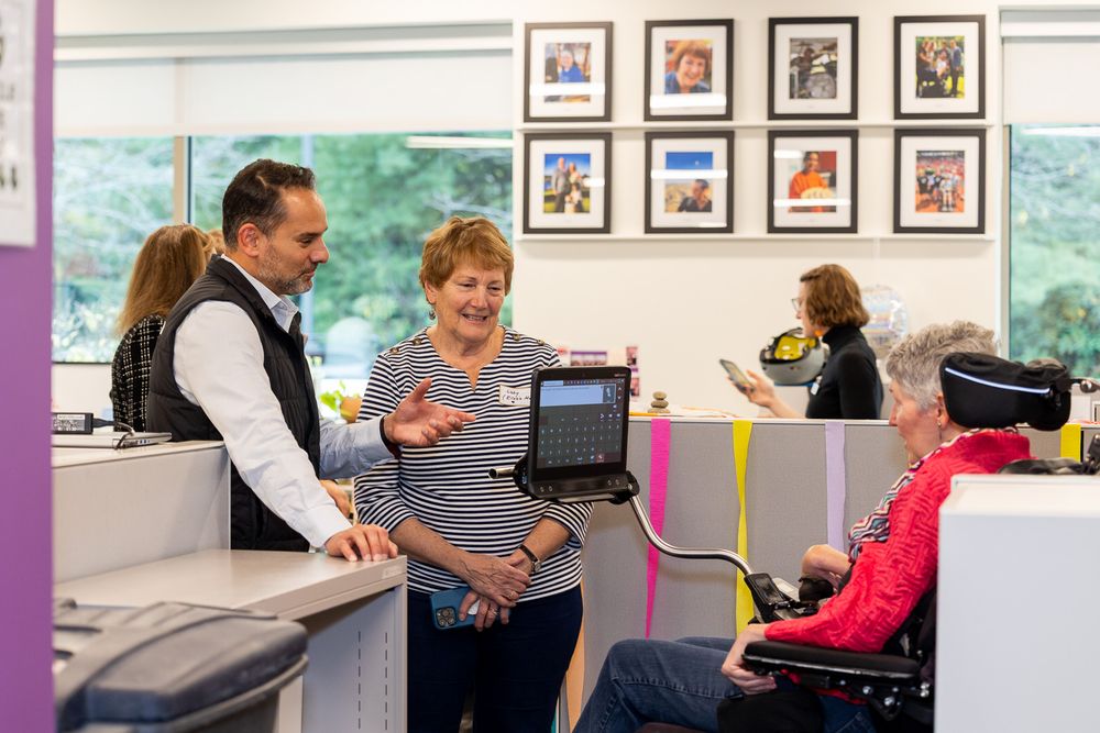 Healthcare worker demonstrates physical therapy exercises to a patient in a medical facility.