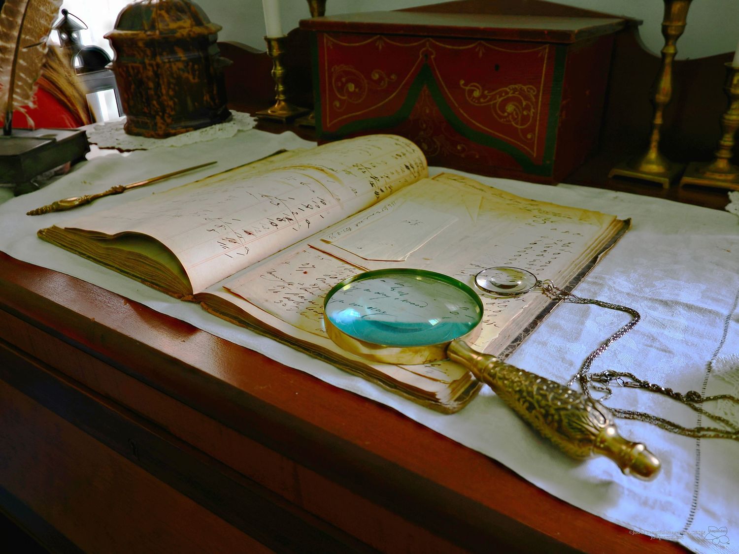 Resplendent photo of a ledger on a desk with a magnifying glass and eyepiece.