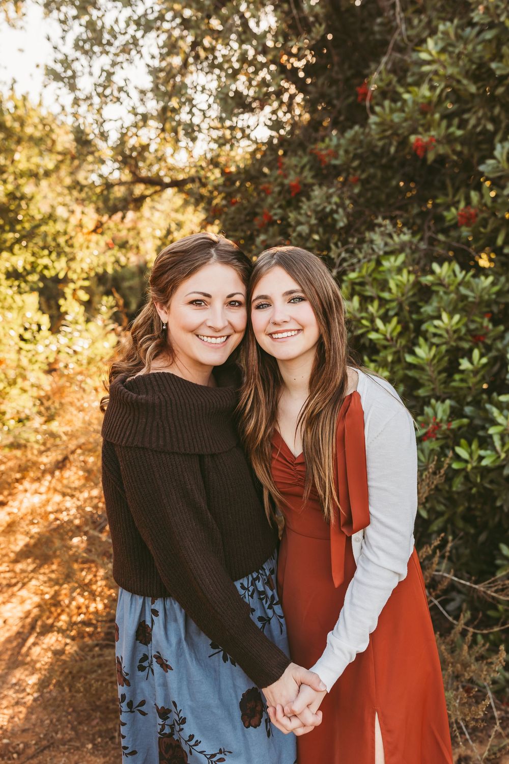 Family members share joyful candid moments together in a fall outdoor setting with golden sunlight.