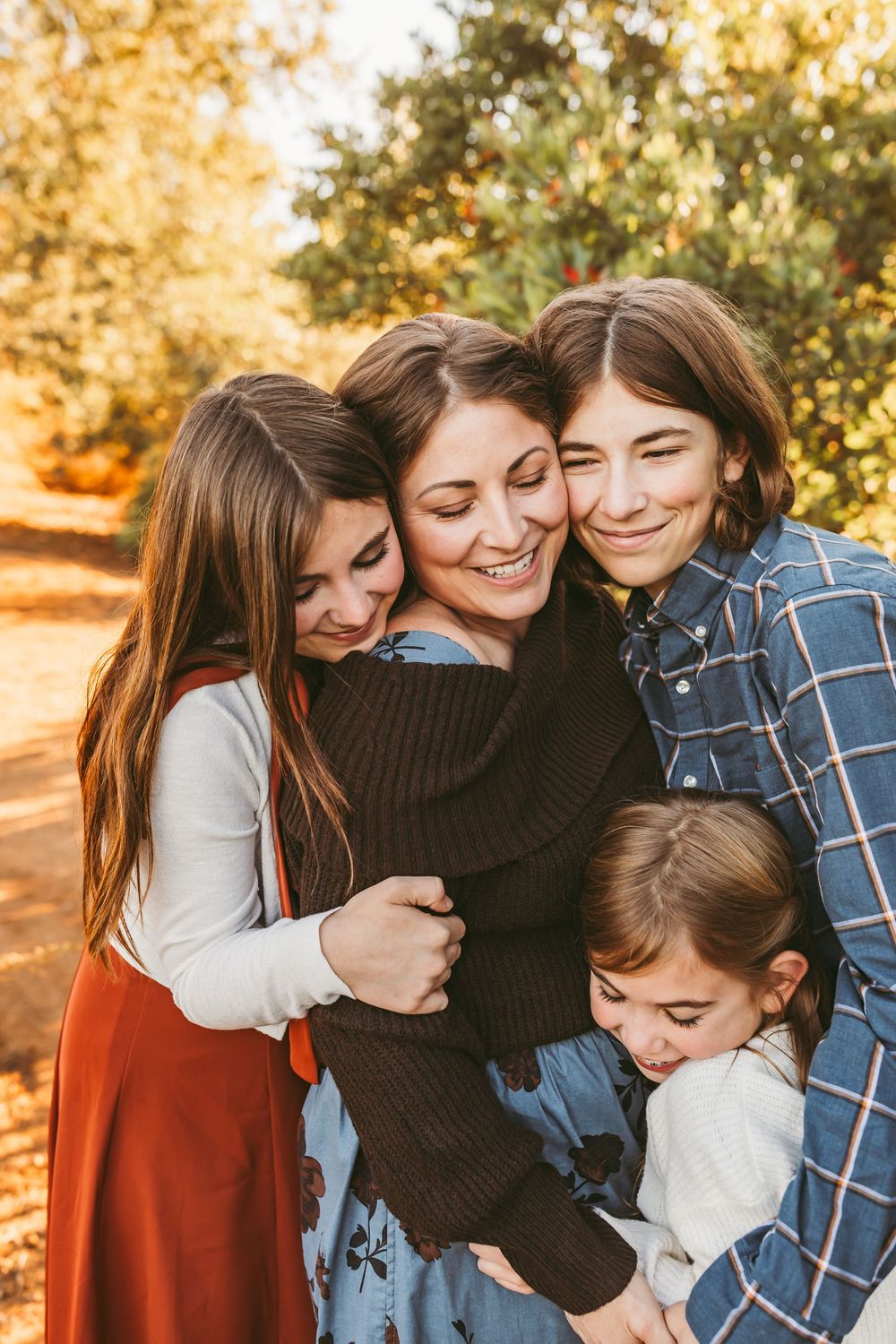 Series of playful group hugs and candid moments captured in golden hour lighting among family members.