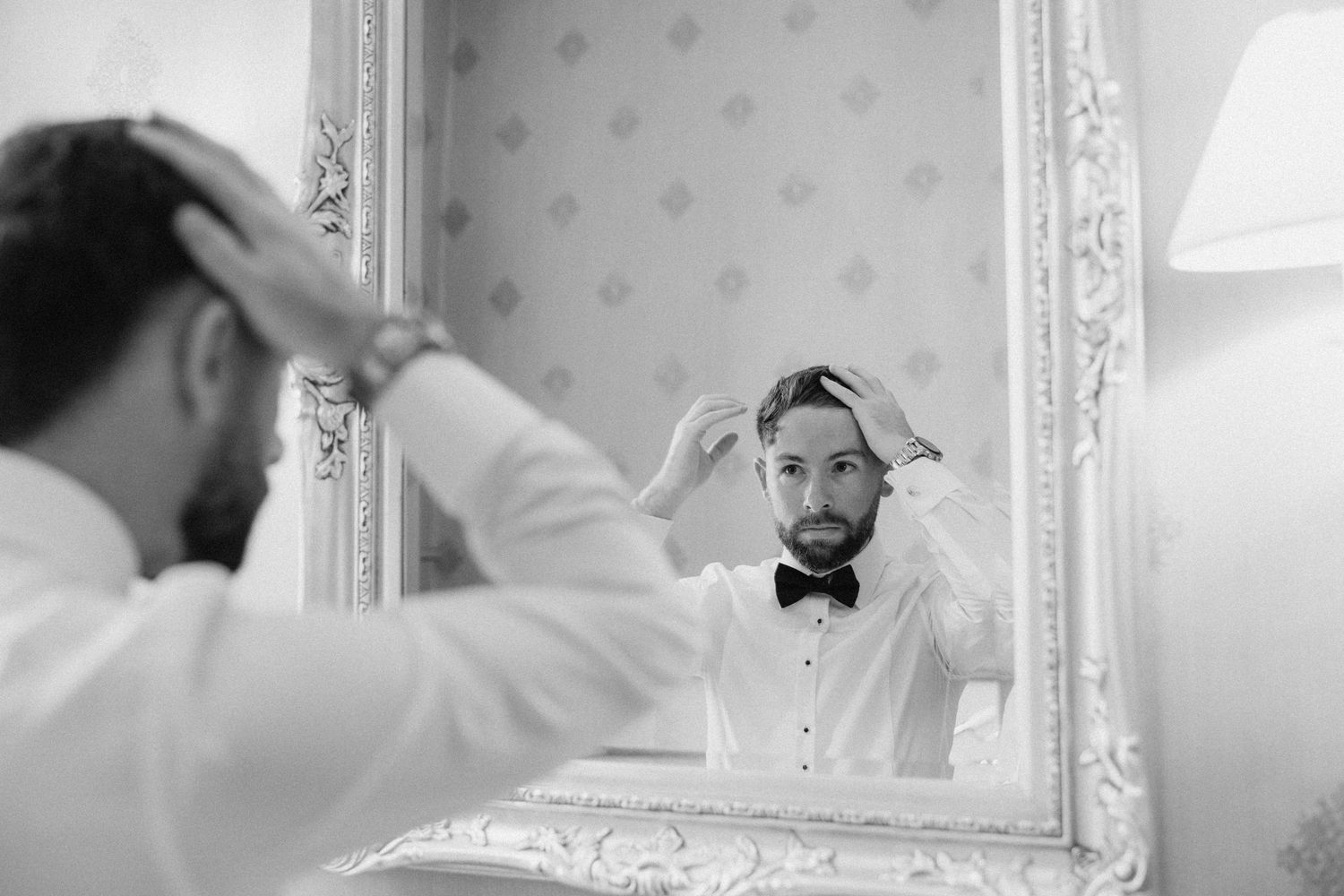 Wedding preparation scene showing someone getting ready in front of an ornate mirror.