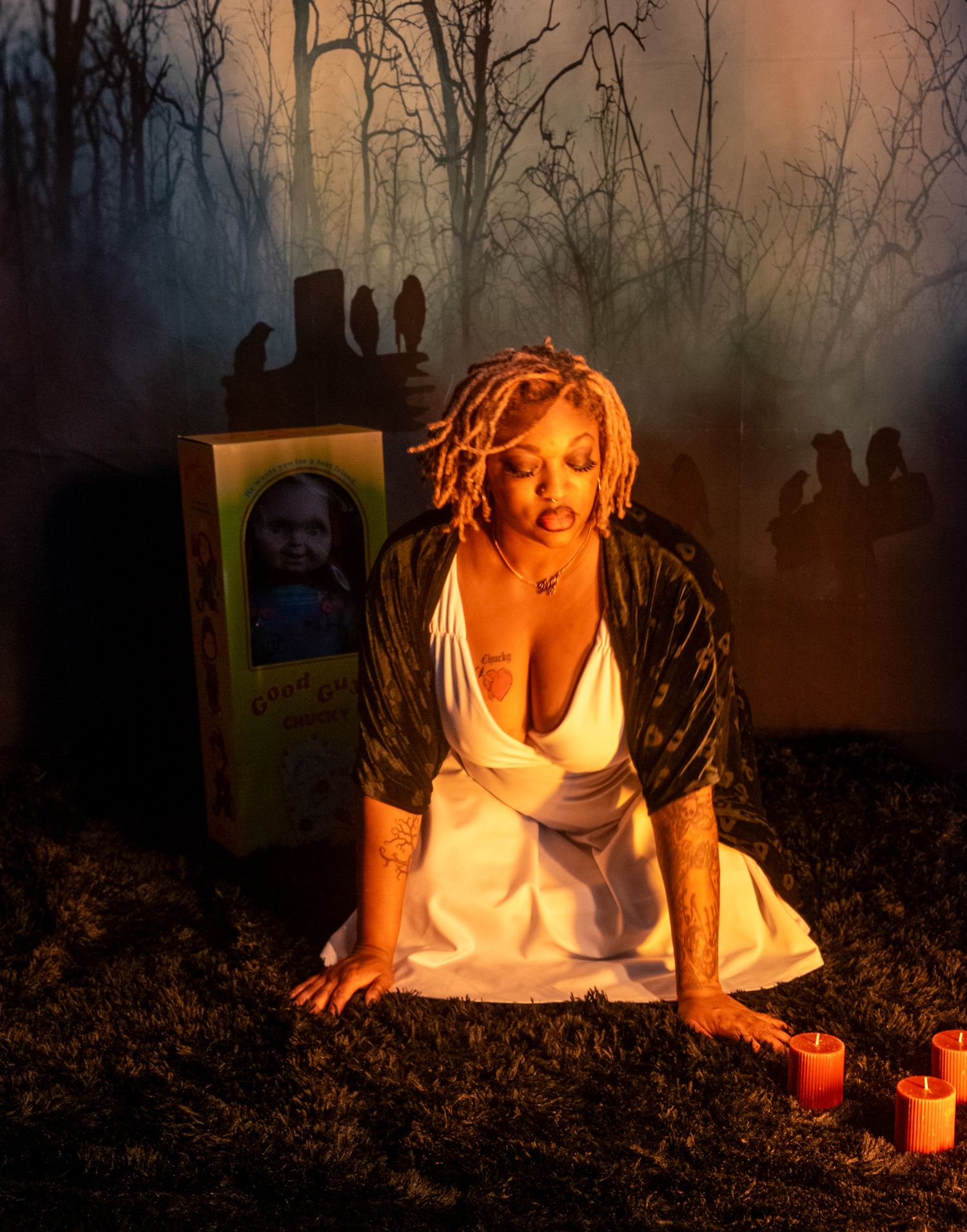 A haunting sequence of a person in white lying on dark forest ground with candles creating an eerie atmosphere.