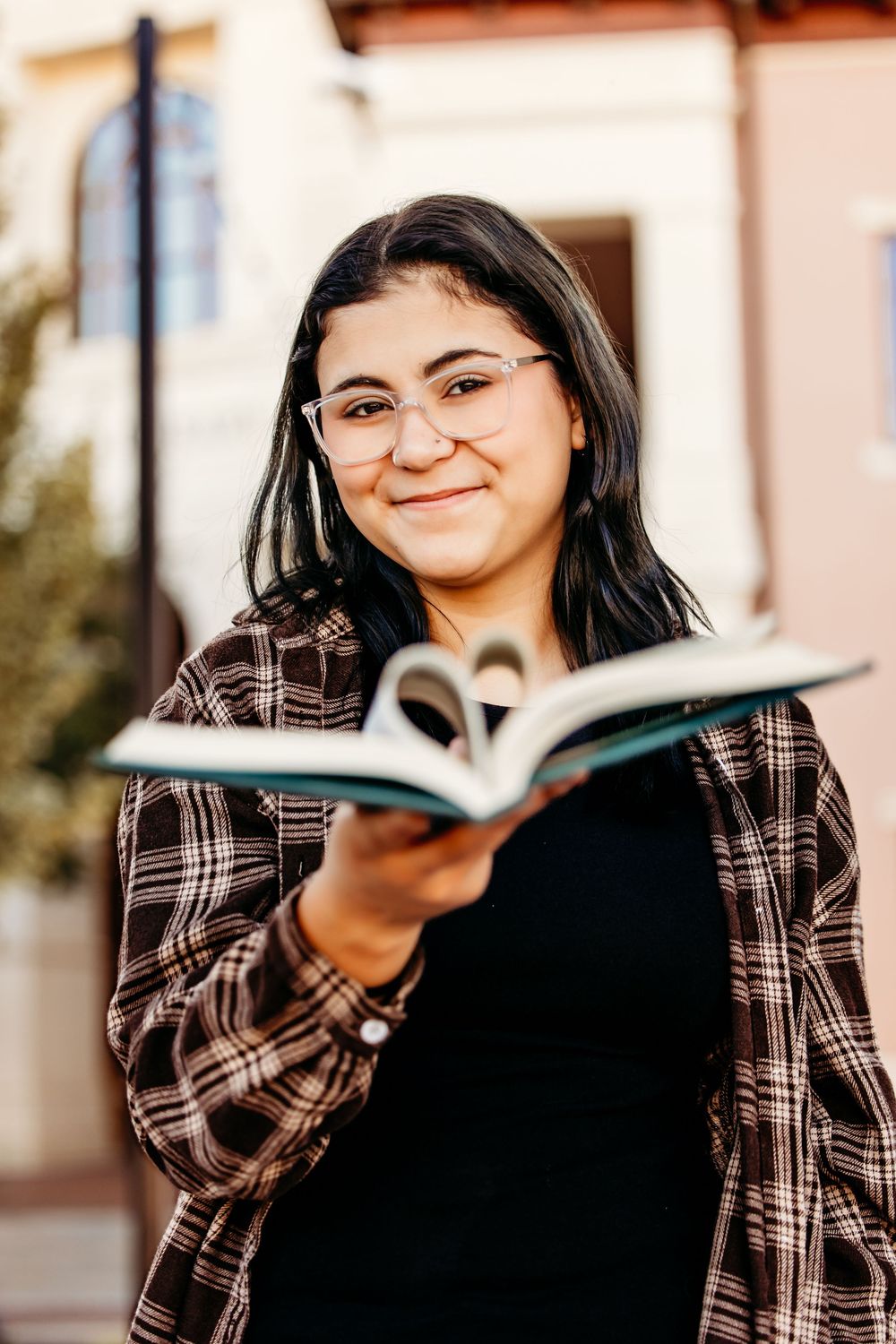 Person in plaid jacket reading a book outside with joyful expressions in a series of connected photos.