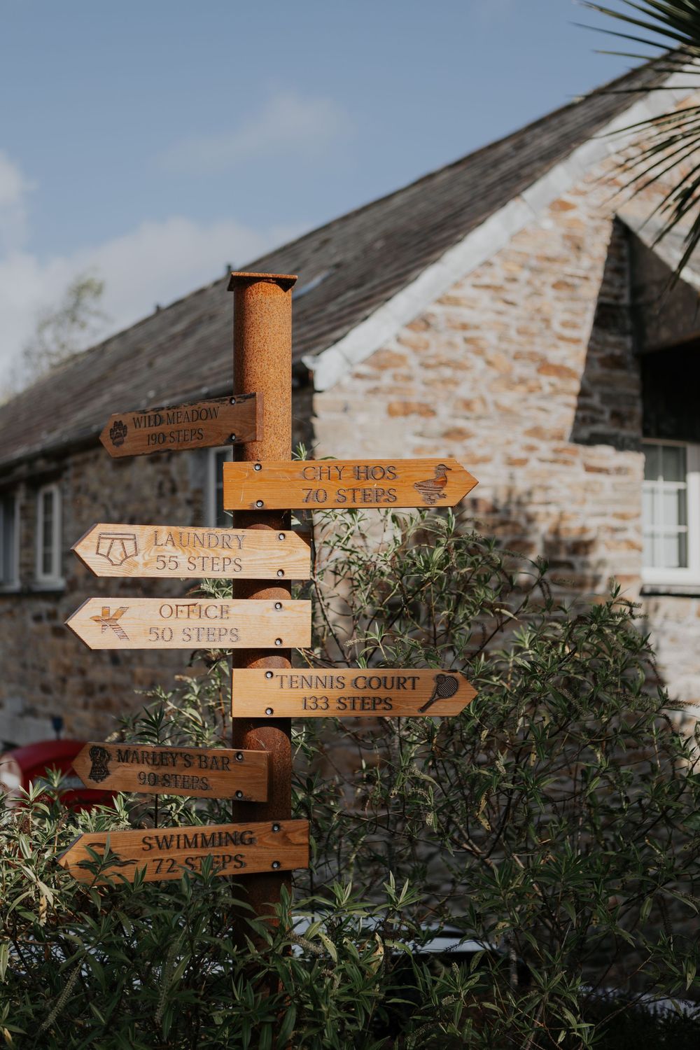 Rustic wooden directional signpost with distance markers at Kilminorth wedding venue, Cornwall.
