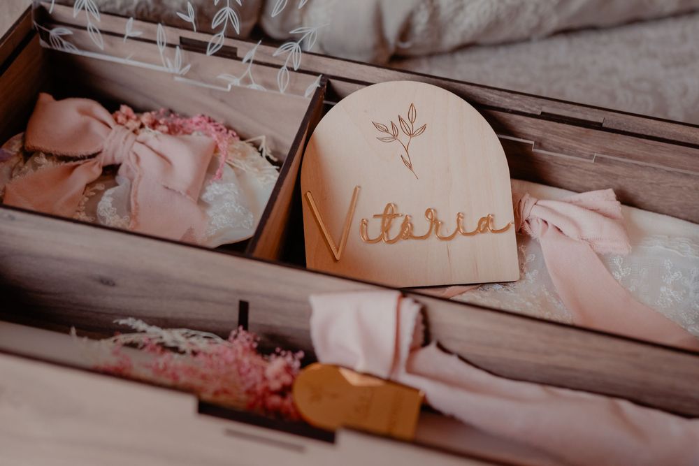 Soft pink ballet tutus and dance attire arranged in a row on wooden floorboards.