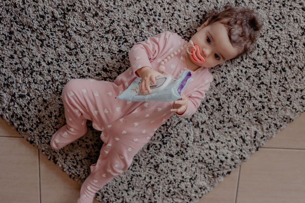 A patterned gray carpet provides a soft play area in a modern home setting.