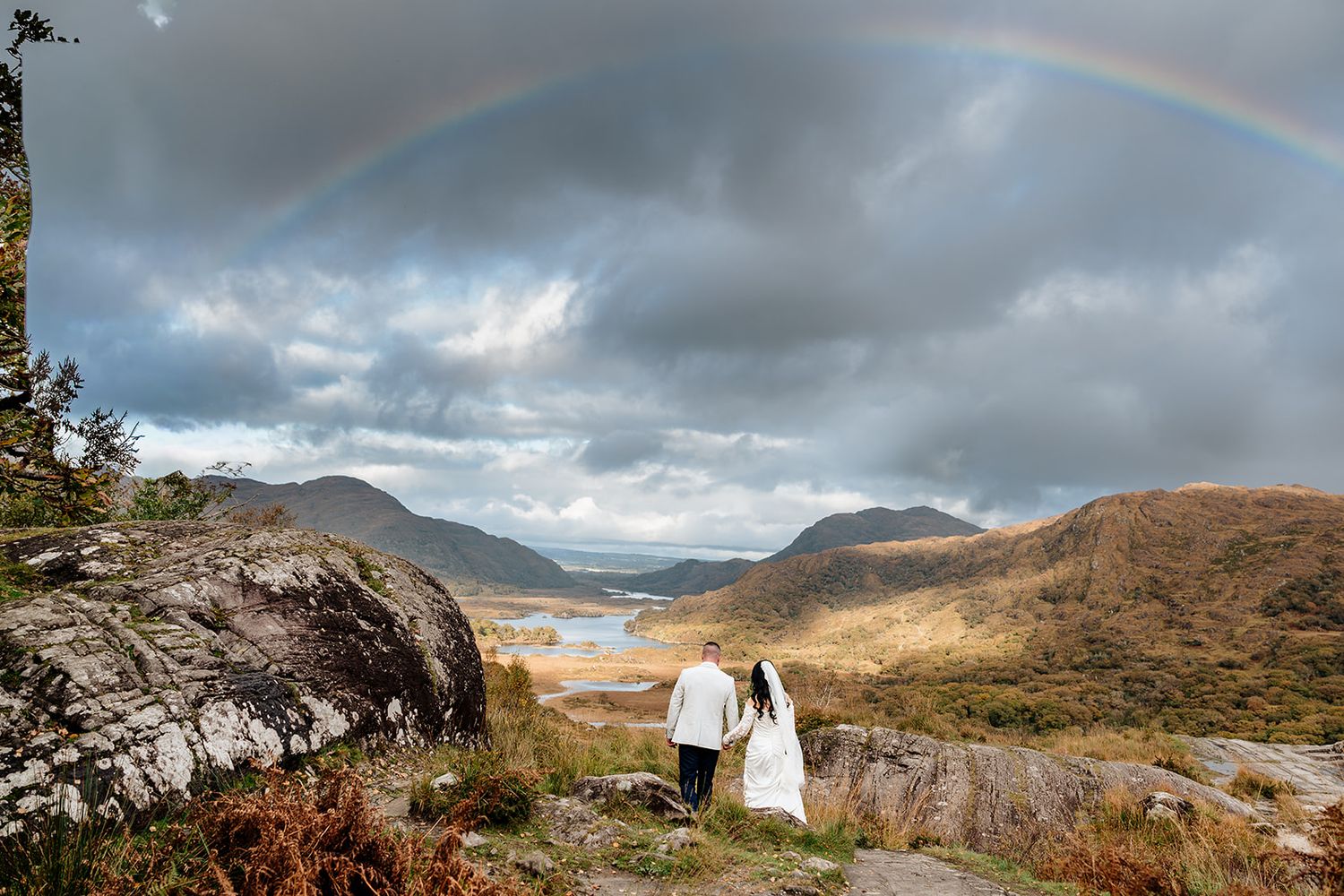 A panoramic mountain landscape with dramatic cloudy skies and rugged terrain stretches across multiple connected images.