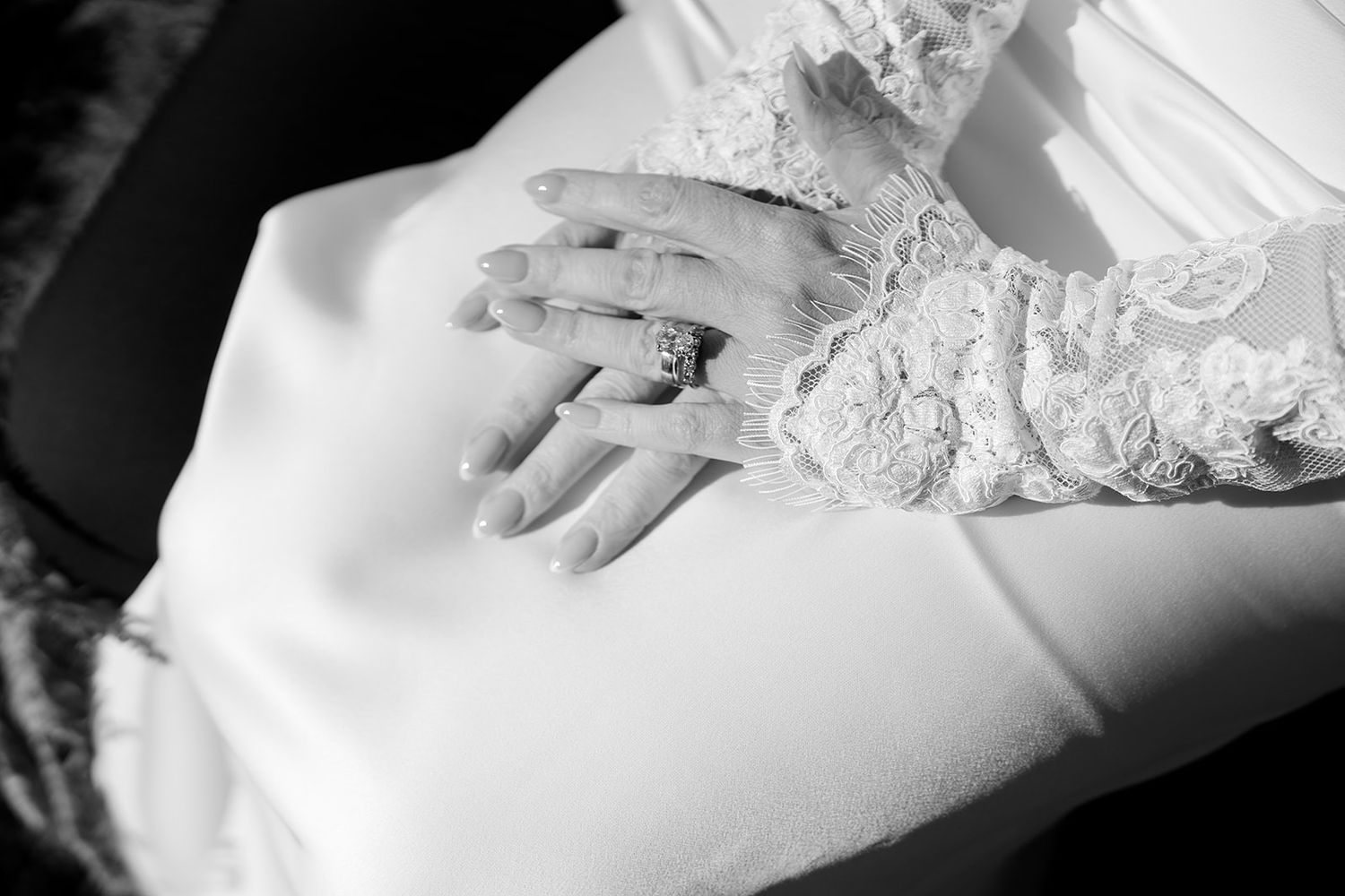 Close-up detail shots of delicate white lace and beading on wedding dress fabric.