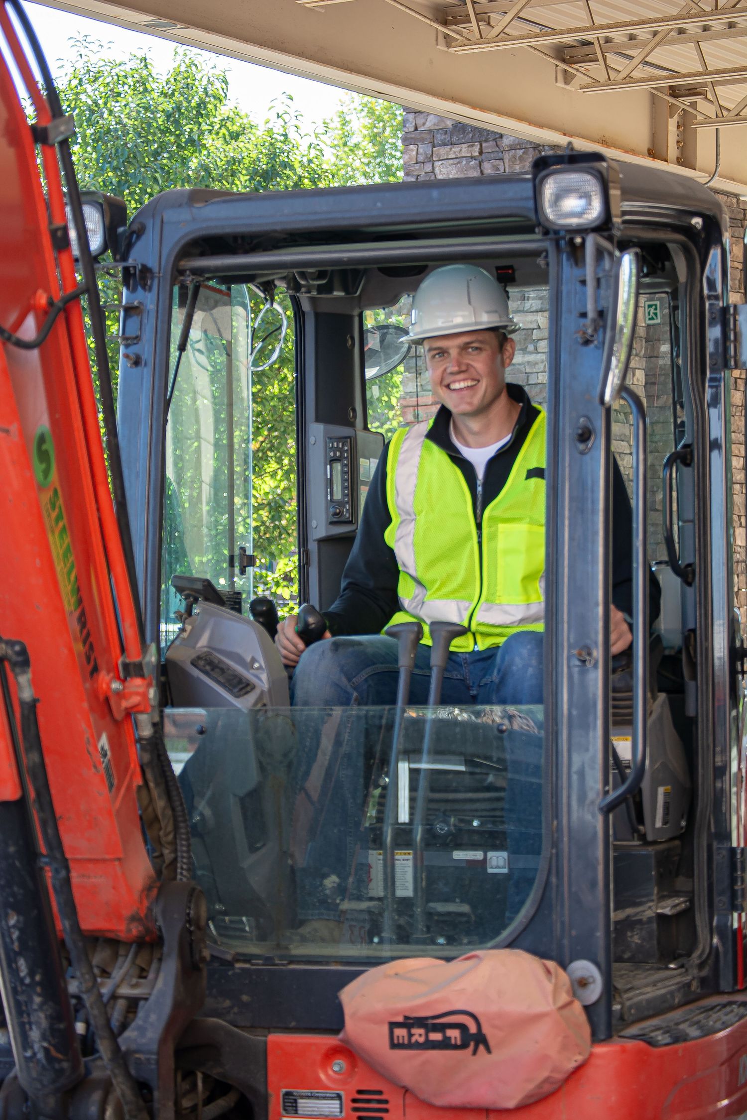 David from Black Swan Excavation running his excavator machine in sherwood park alberta, pull safety gear, ppe, happy guy in his machine