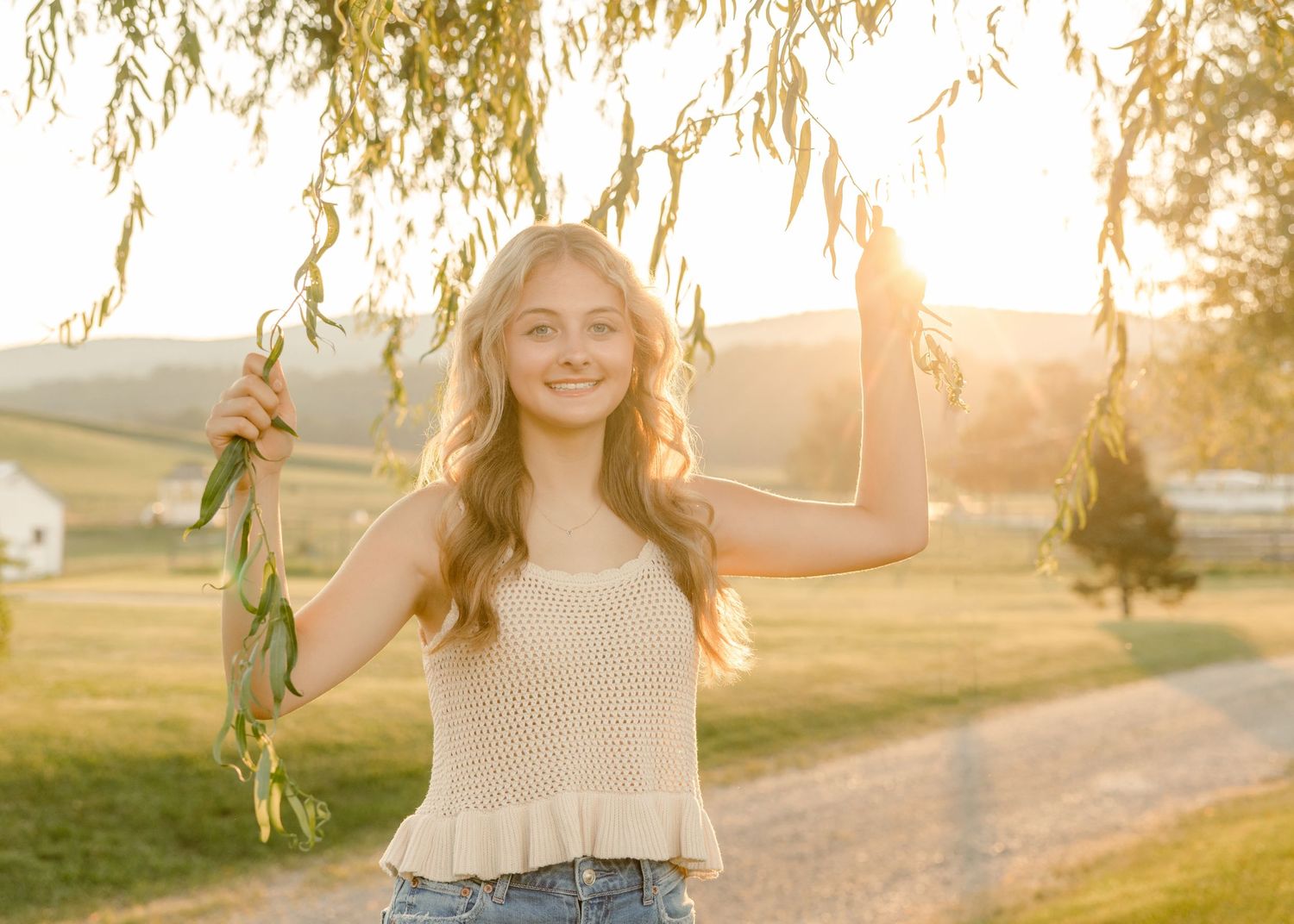 Outdoor portrait session under weeping willow trees at golden hour.