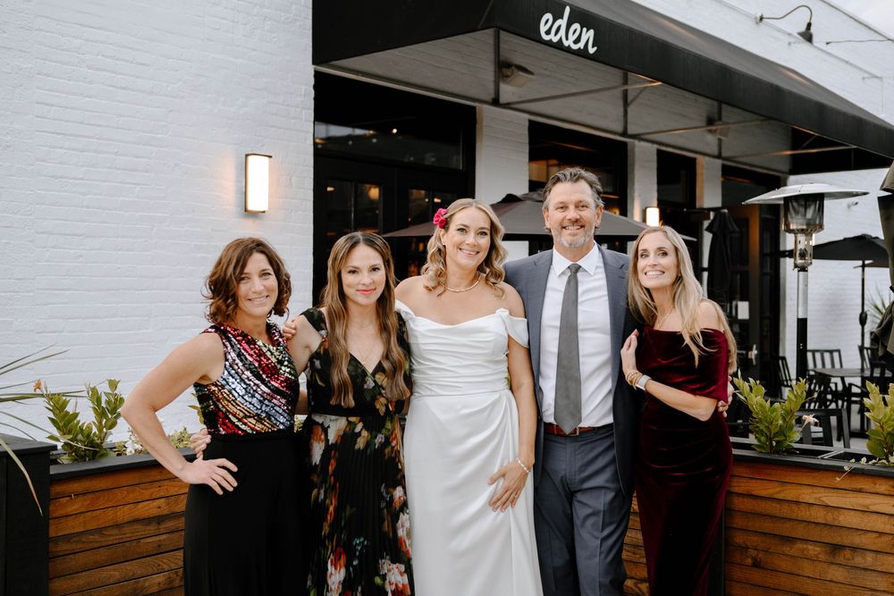 Wedding guests mingling and socializing at an indoor reception venue with modern decor and wooden accents.