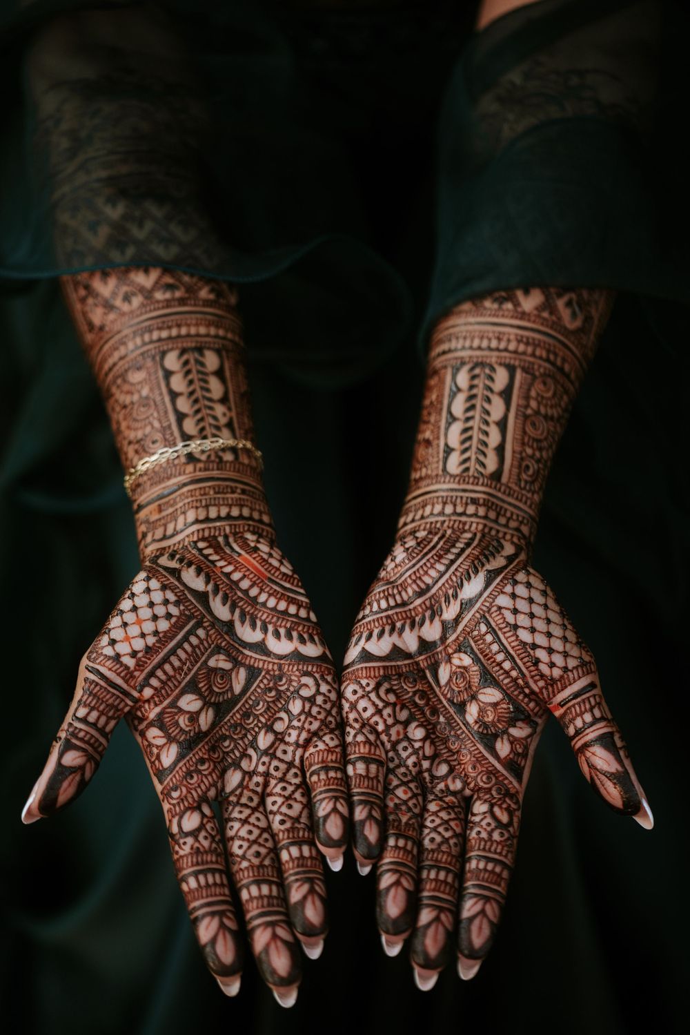 Intricate bridal mehndi design progression showing detailed henna patterns on palms from simple to complex stages.