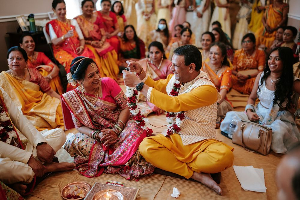 Wedding guests in traditional Indian attire gather in a row during a cultural celebration ceremony.