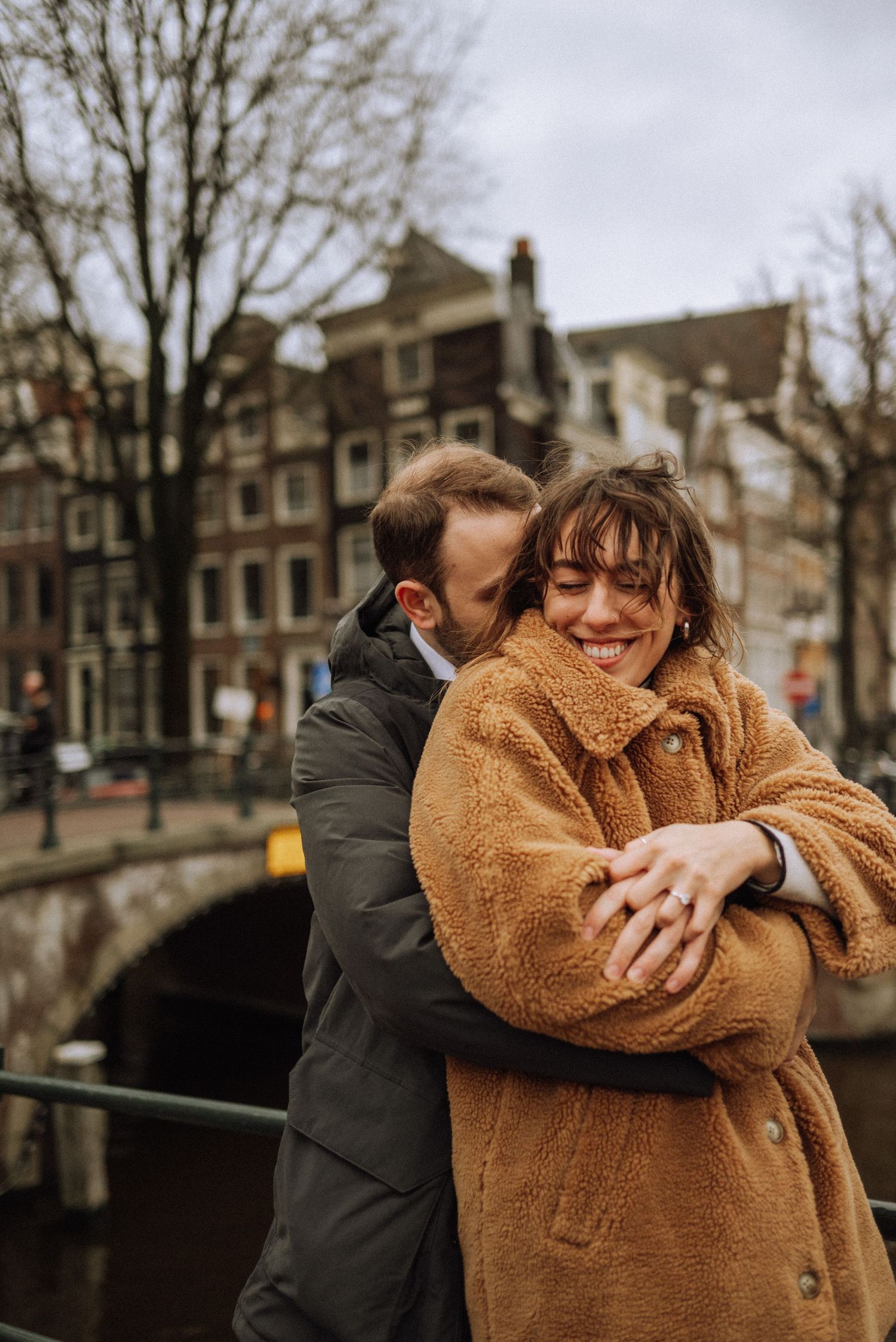 A tight embrace on a bridge over an Amsterdam canal – an authentic moment with true emotions.