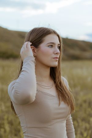 Portrait of a person in beige sweater against a natural autumn landscape.