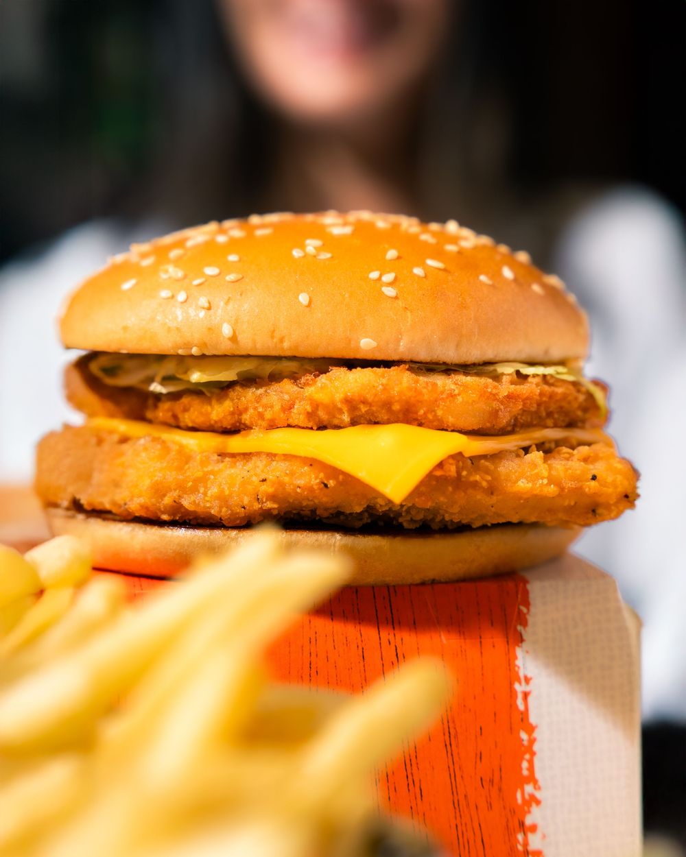 A series of fast food cheeseburgers with golden buns and melted cheese shown in varying close-up angles.