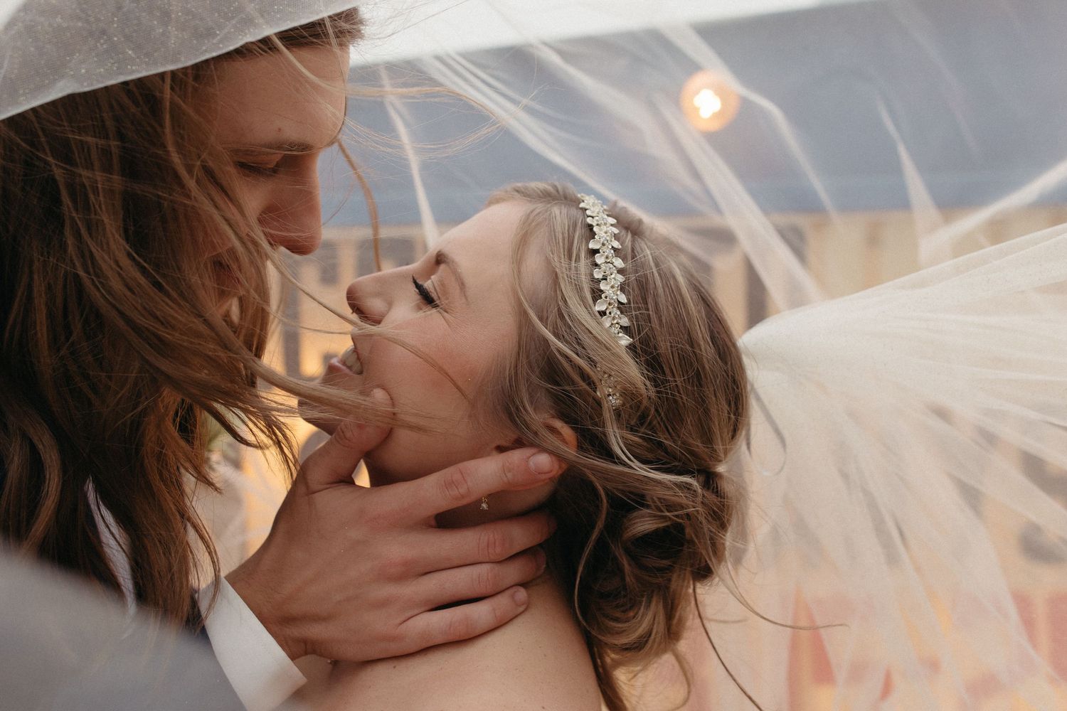 Couple dancing outdoors among evergreen trees with bride's dress flowing.