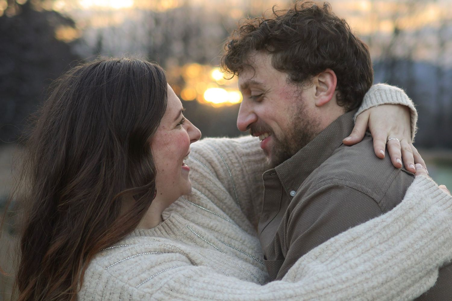 Couple sharing intimate moments at sunset in an urban setting.