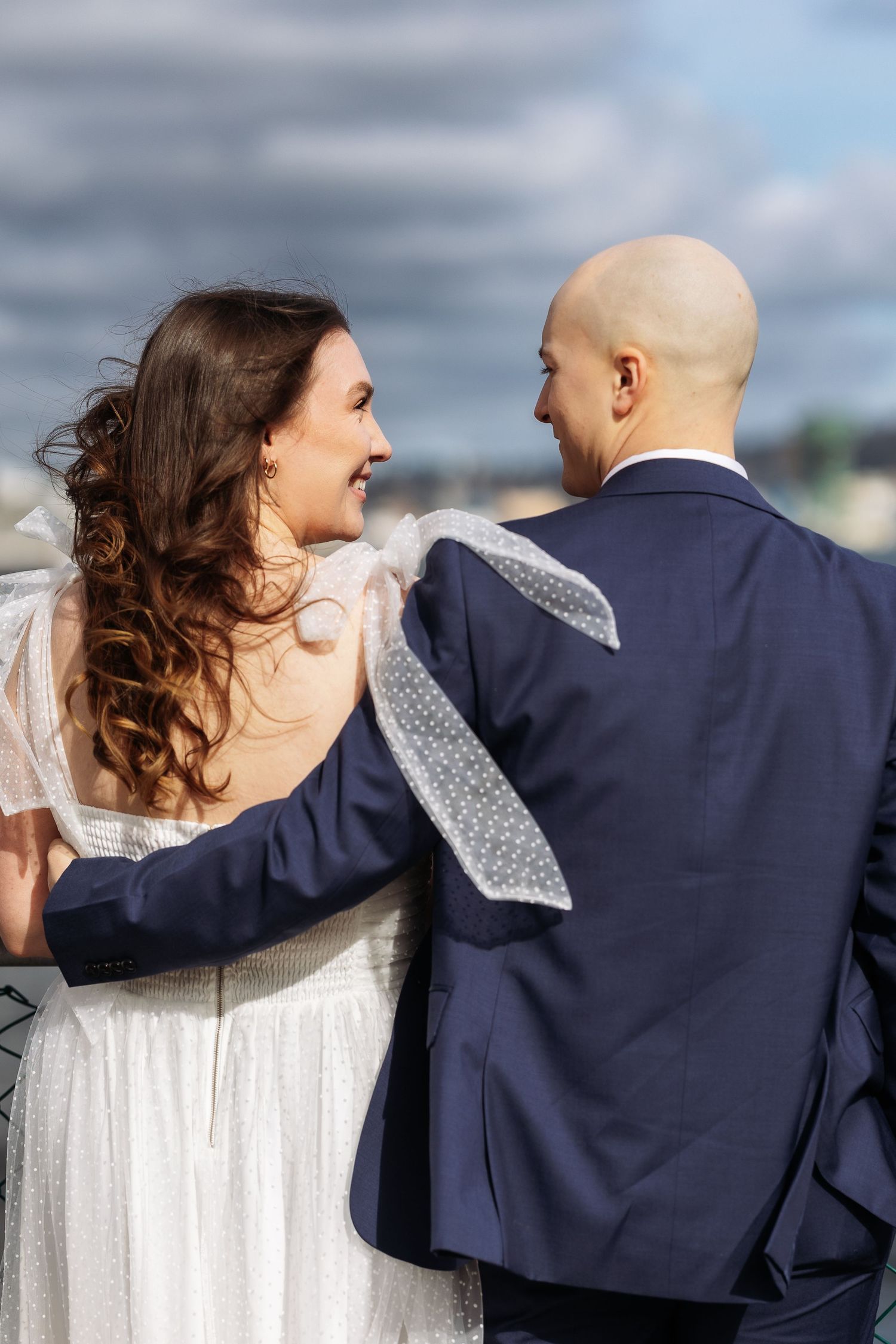 A couple in wedding attire share intimate moments in a sequence of candid outdoor photos.