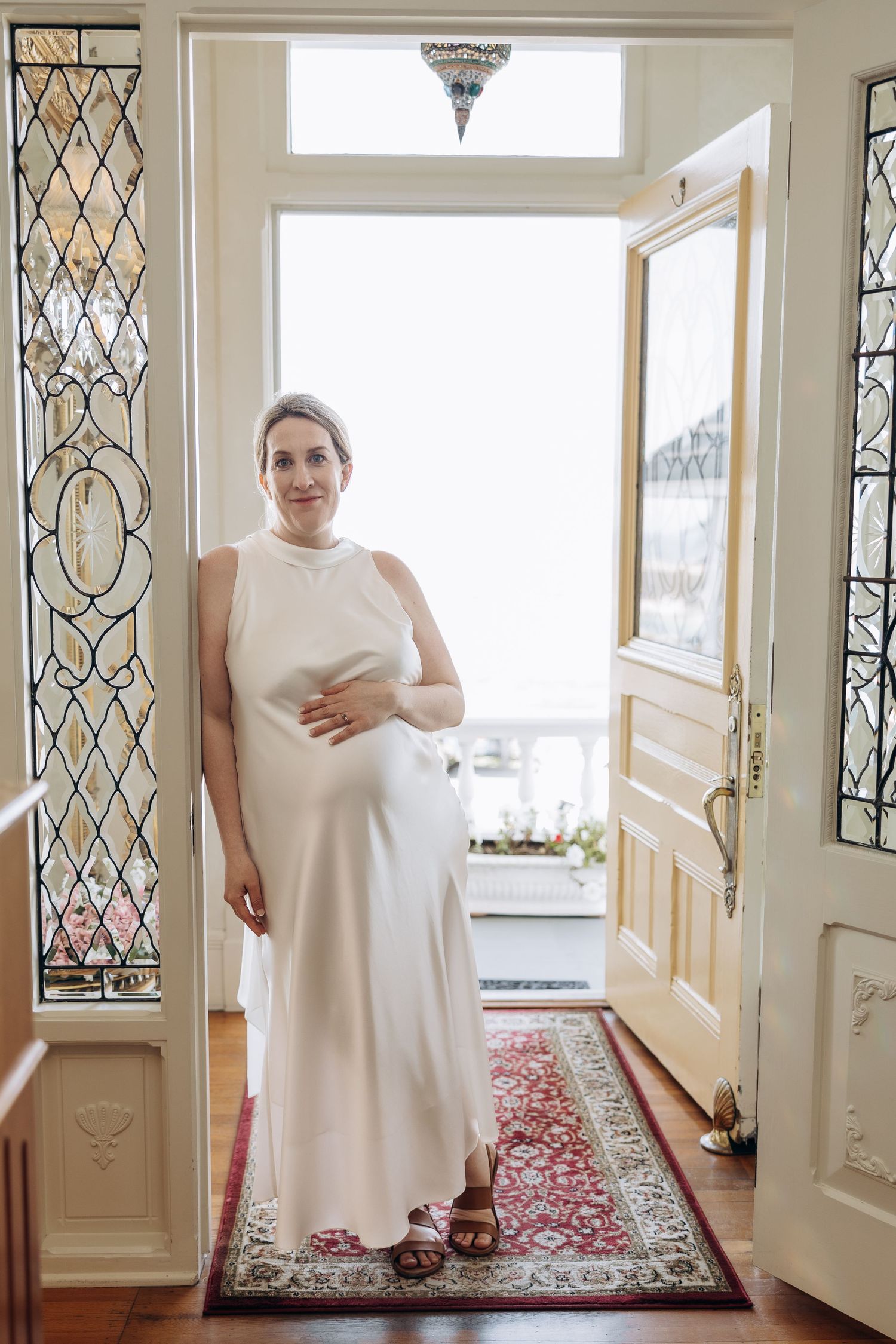 A series of four connected photos showing someone in a white dress standing in a bright interior space with decorative windows.