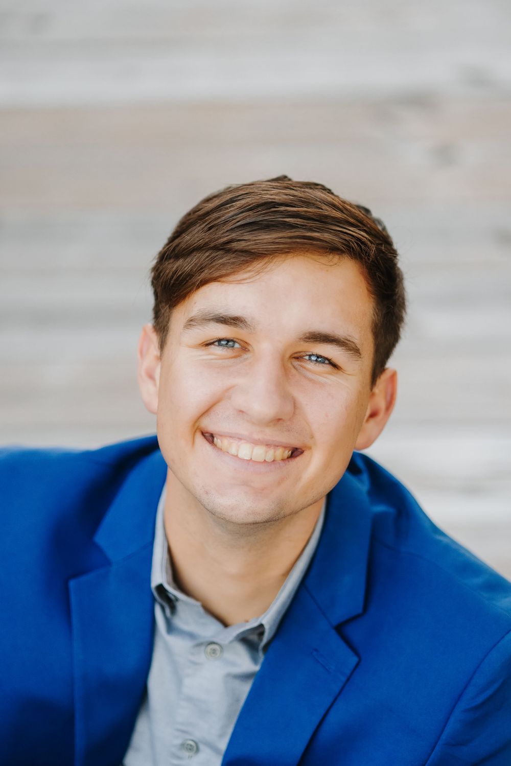 Professional headshots of person in blue blazer showing different expressions against light background.
