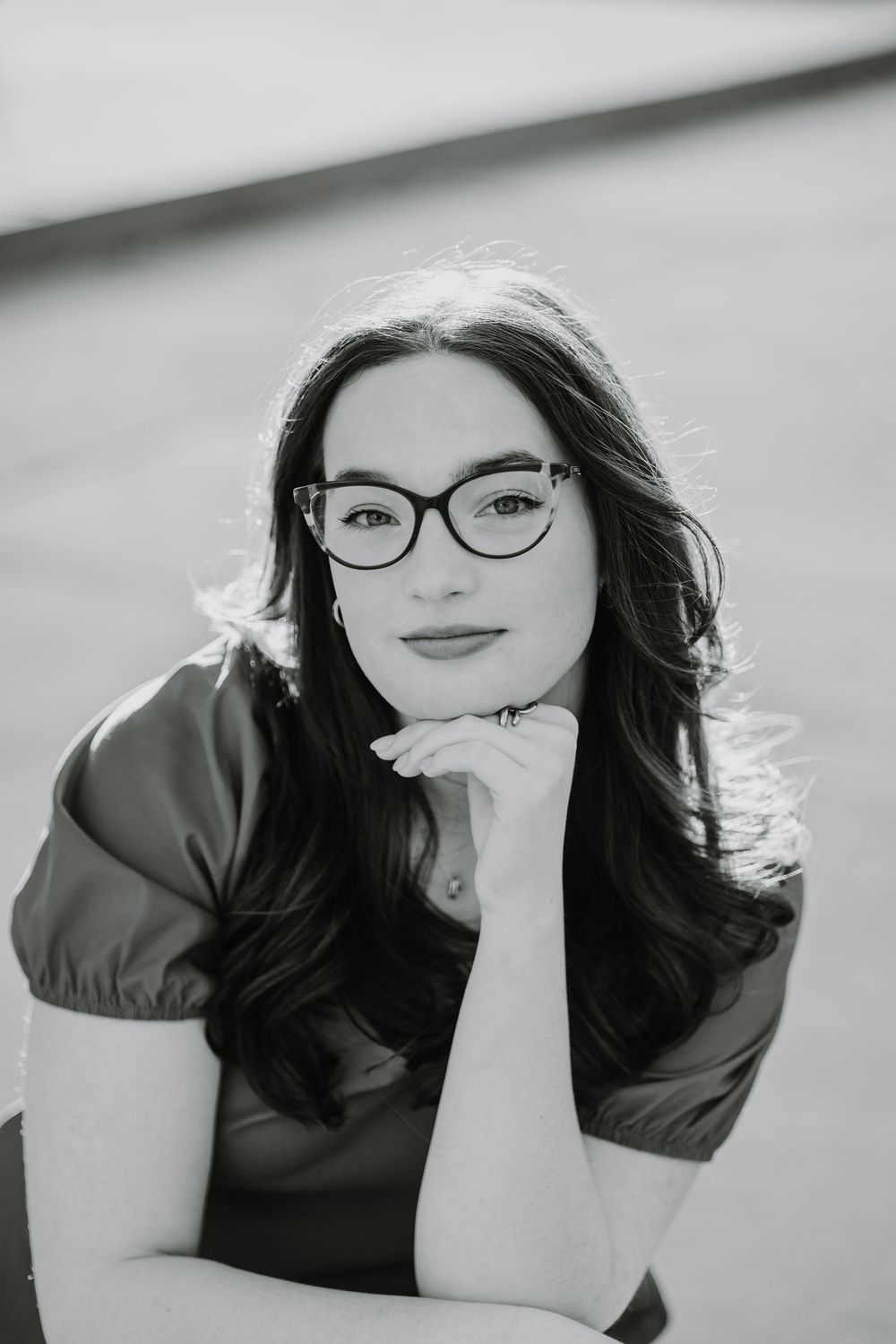 A black and white portrait series showing someone in a dark top posing against a light background.