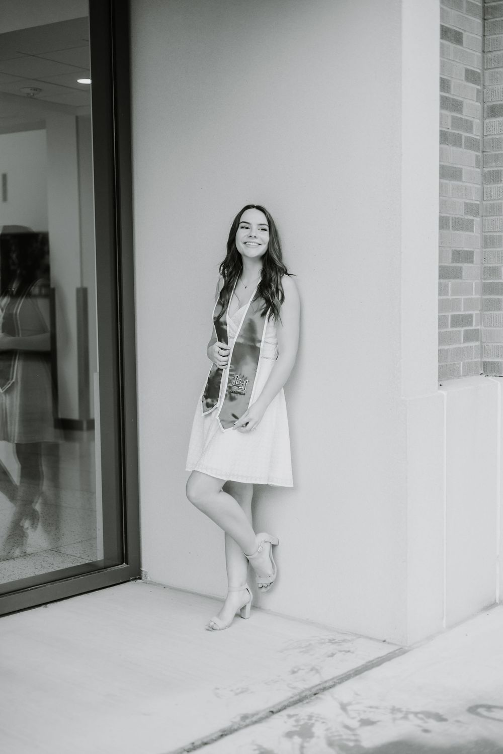 A series of black and white photos showing someone sitting and laughing on an outdoor patio with glass windows.