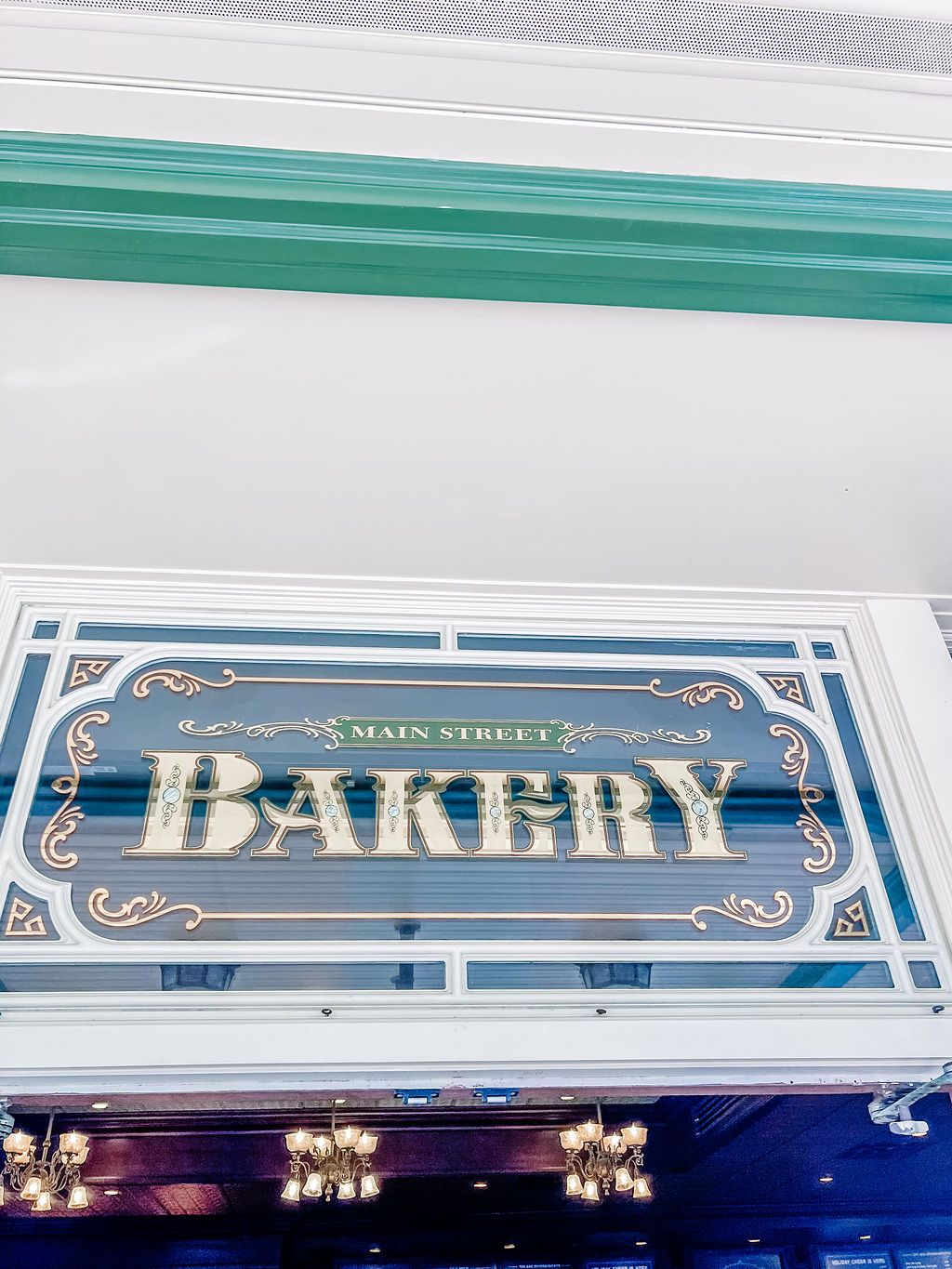 Decorative vintage storefront signs featuring ornate gold lettering and trim details on dark backgrounds.