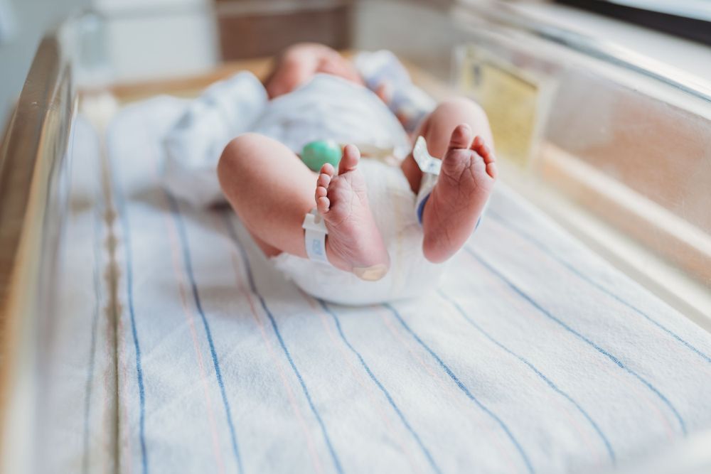 Close-up of tiny newborn feet with hospital identification bands.