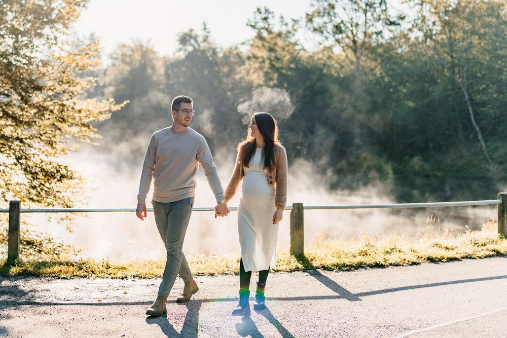 Couple taking a stroll together on a foggy path during golden hour.