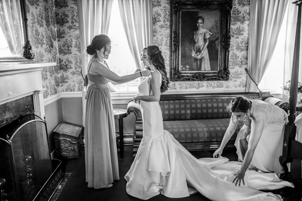 Black and white wedding preparation photos showing vintage interior scenes with elegant curtains and decor.