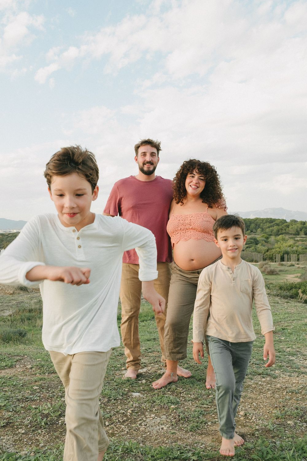 familia esperando un bebé pasea descalza sobre el césped