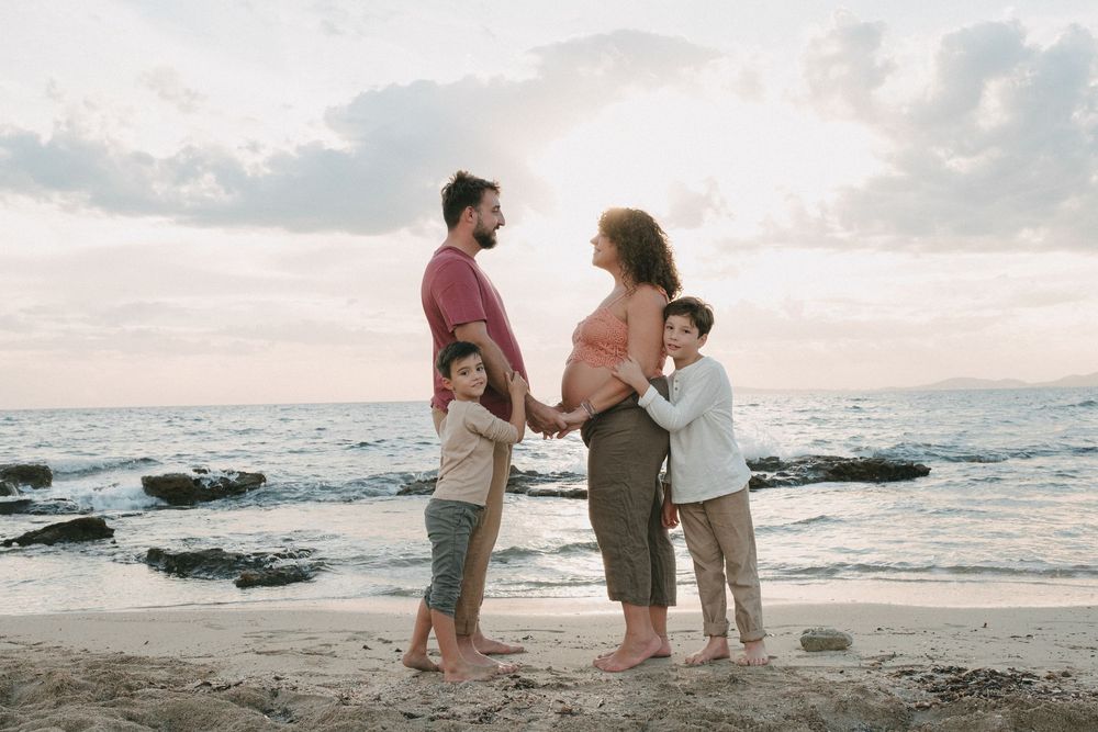 familia posando en la playa con la puesta de sol