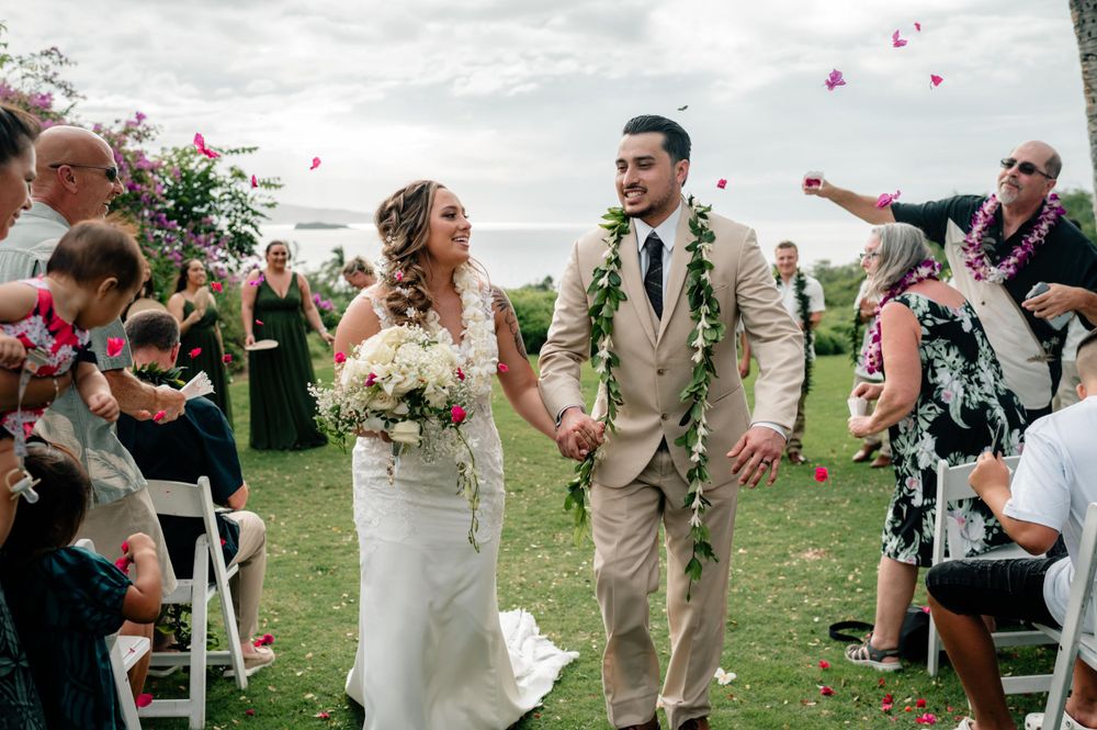 Wedding party celebrating with confetti toss outdoors after ceremony.