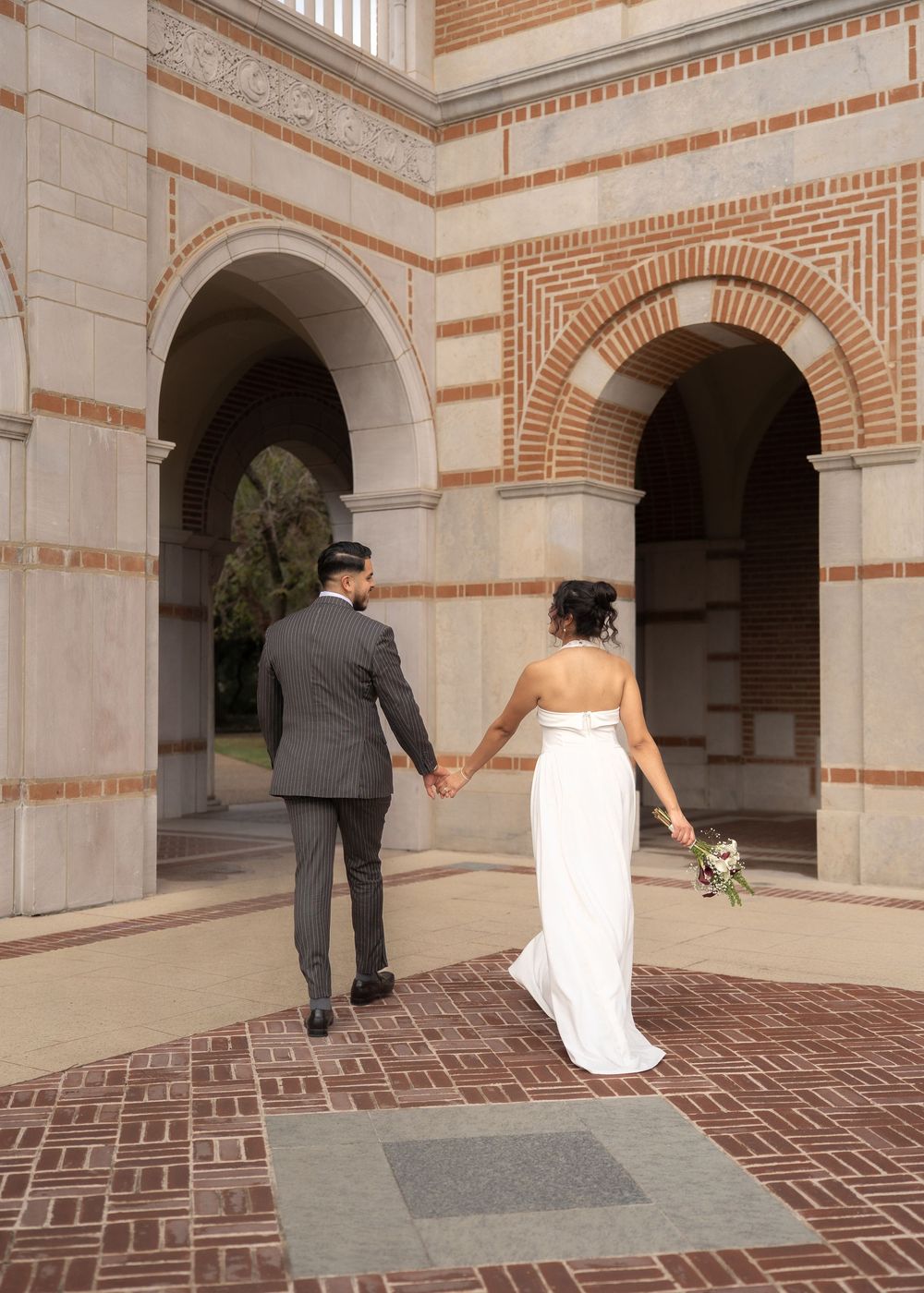 Wedding portraits of Rubi and Joe Yerena in front of Rice University’s iconic Lovett Hall, showing their love and connection.