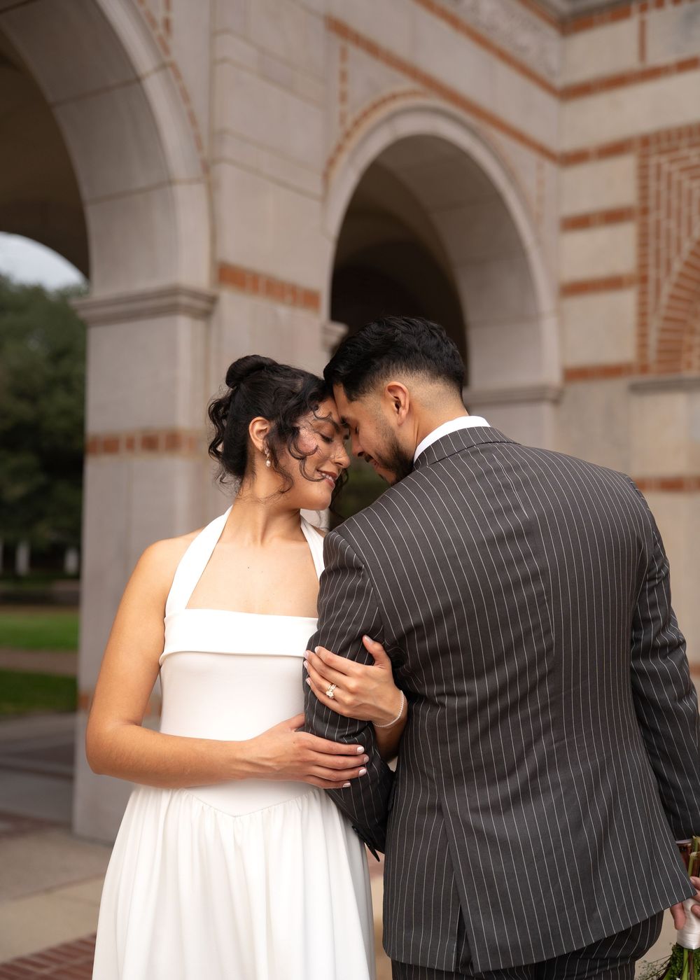 Wedding portraits of Rubi and Joe Yerena in front of Rice University’s iconic Lovett Hall, showing their love and connection.