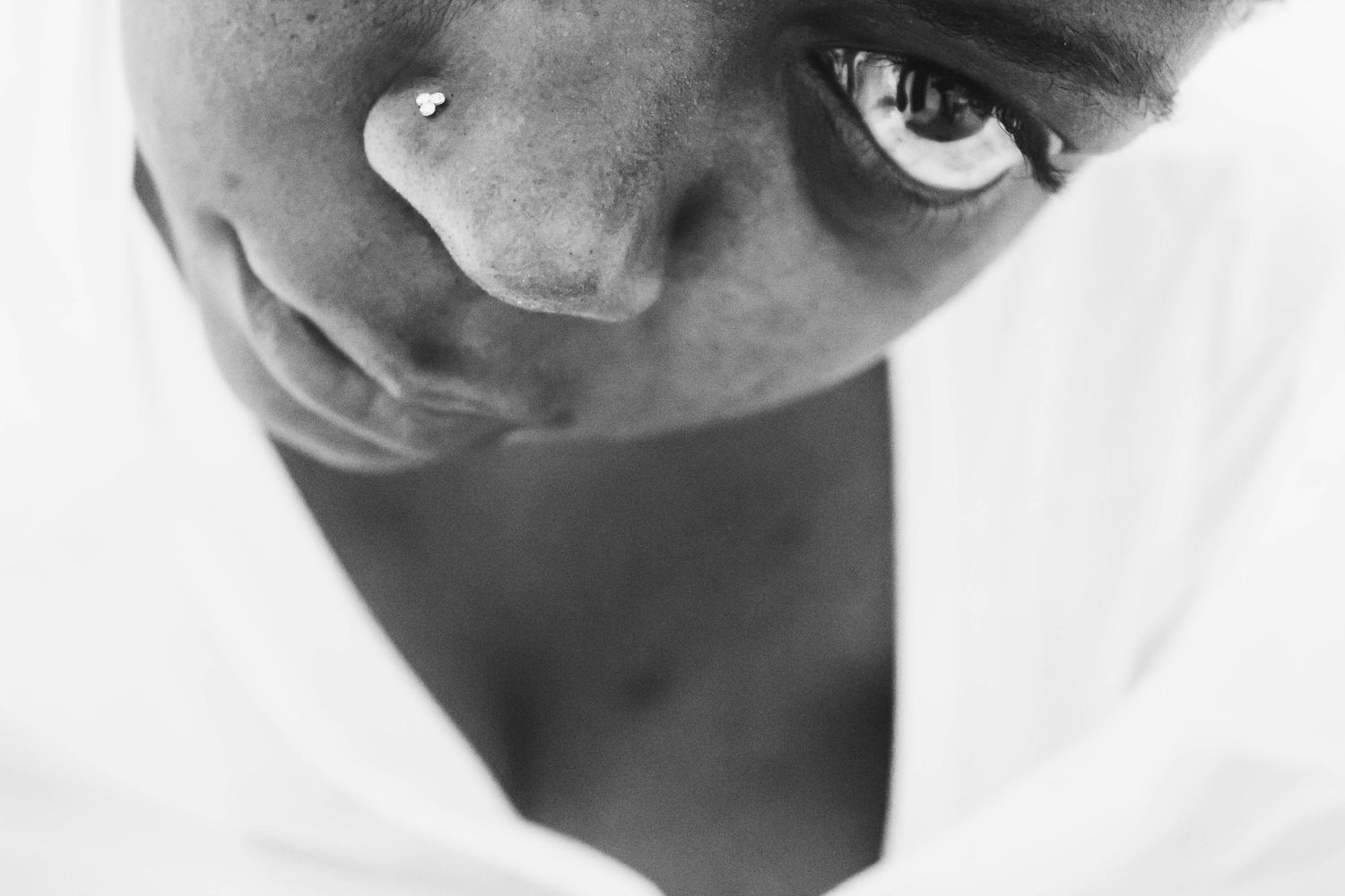 Close-up black and white detail of a wedding dress neckline showing delicate white fabric and plunging V-shape design.