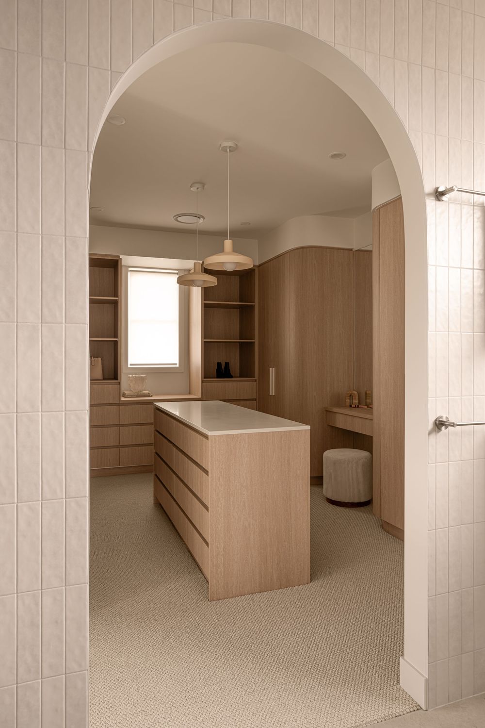 Modern minimalist interior space with arched doorways, light wood built-ins, and beige carpeting throughout.