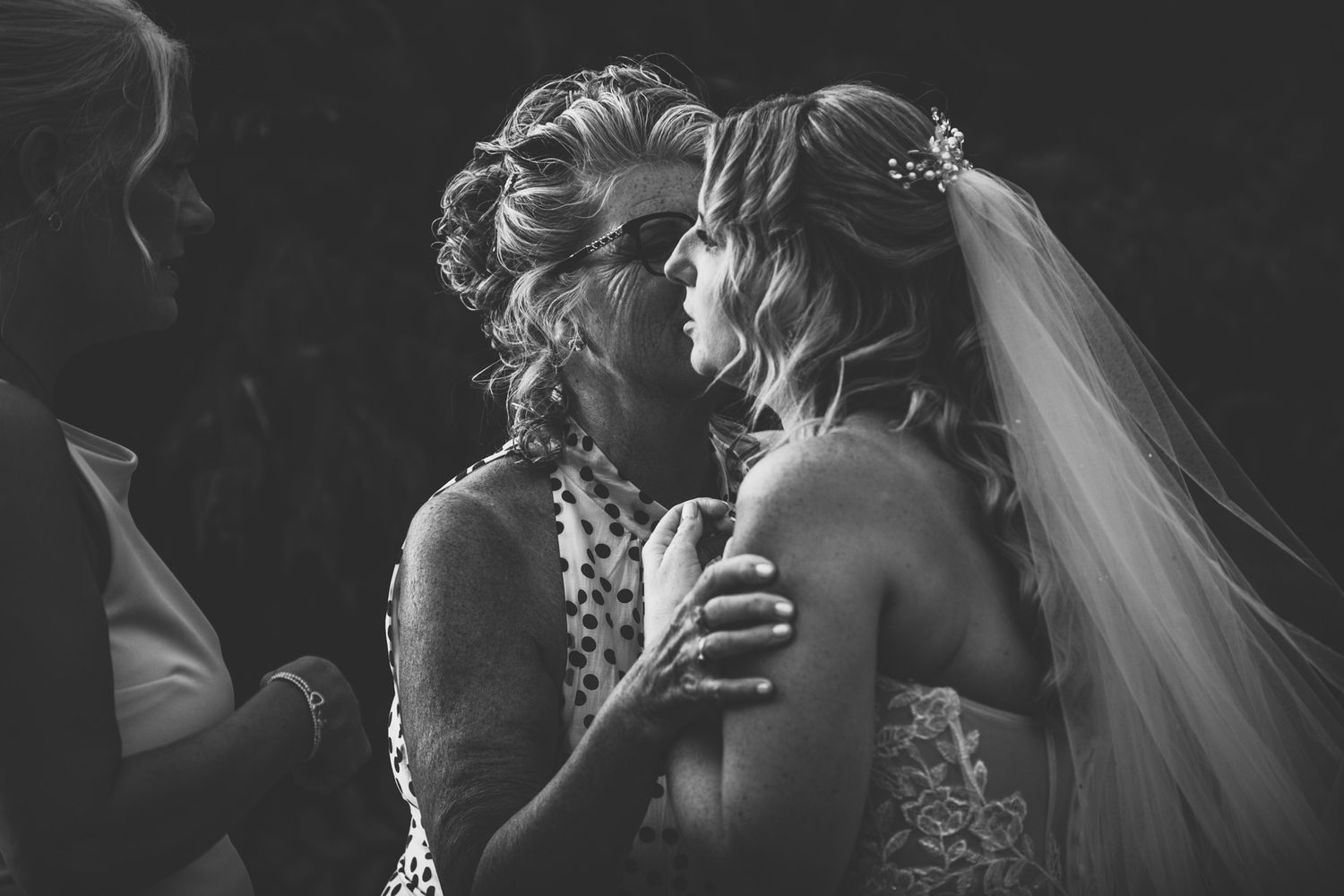 A black and white wedding photograph showing a couple in a candid moment during their celebration.