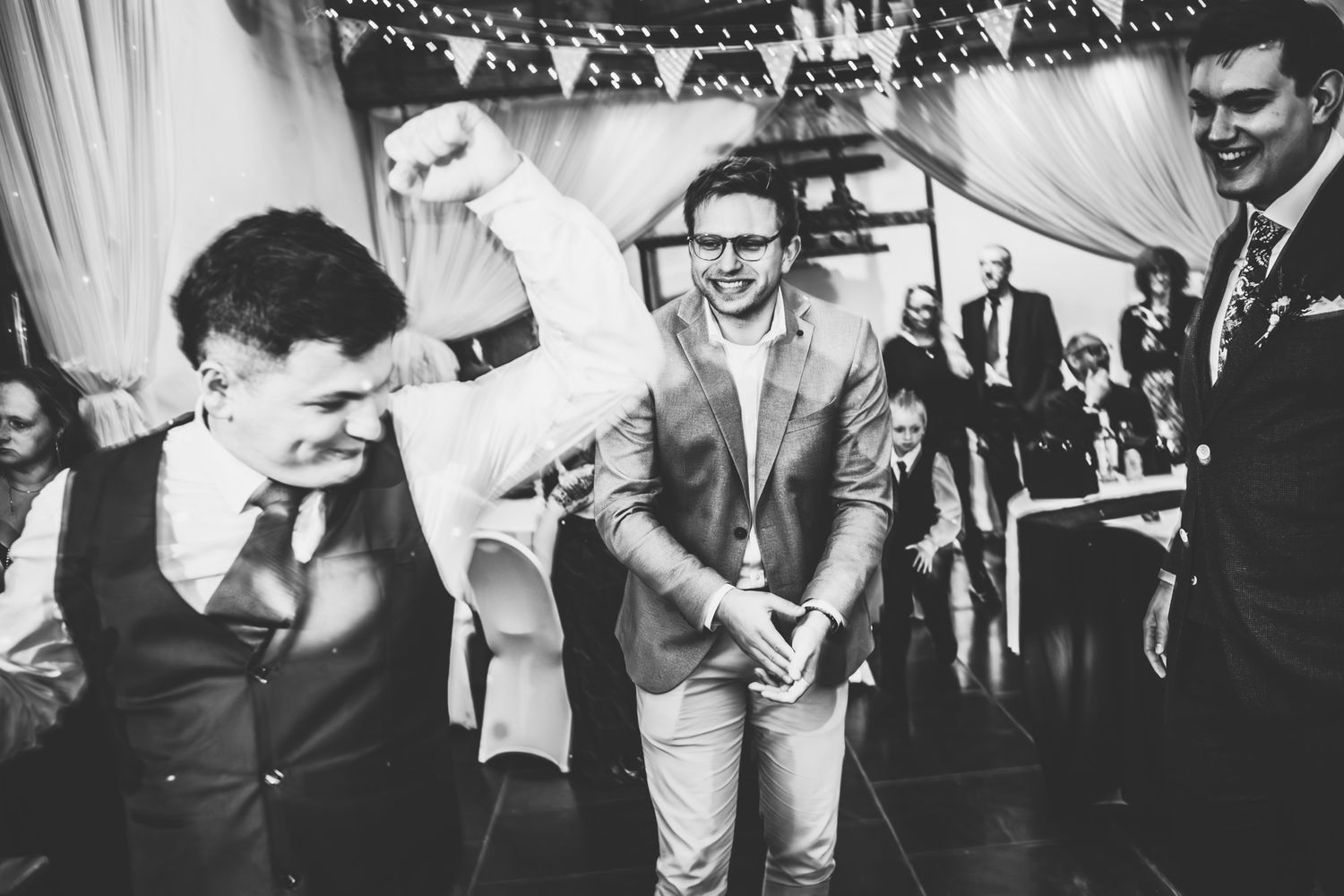 A black and white photo montage showing various dance scenes and celebrations at what appears to be a wedding reception.
