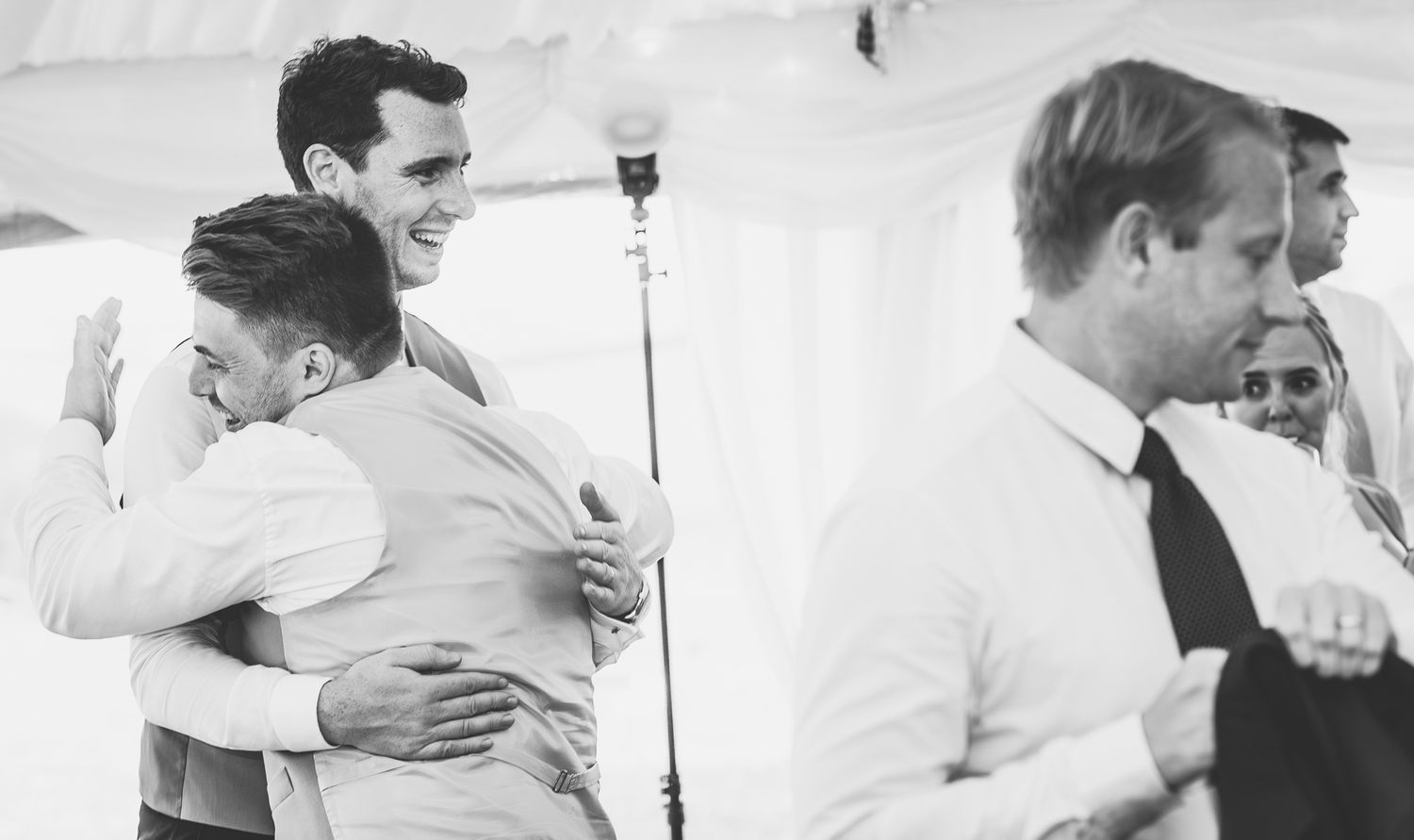 Series of emotional black and white wedding embraces showing tender moments between guests.
